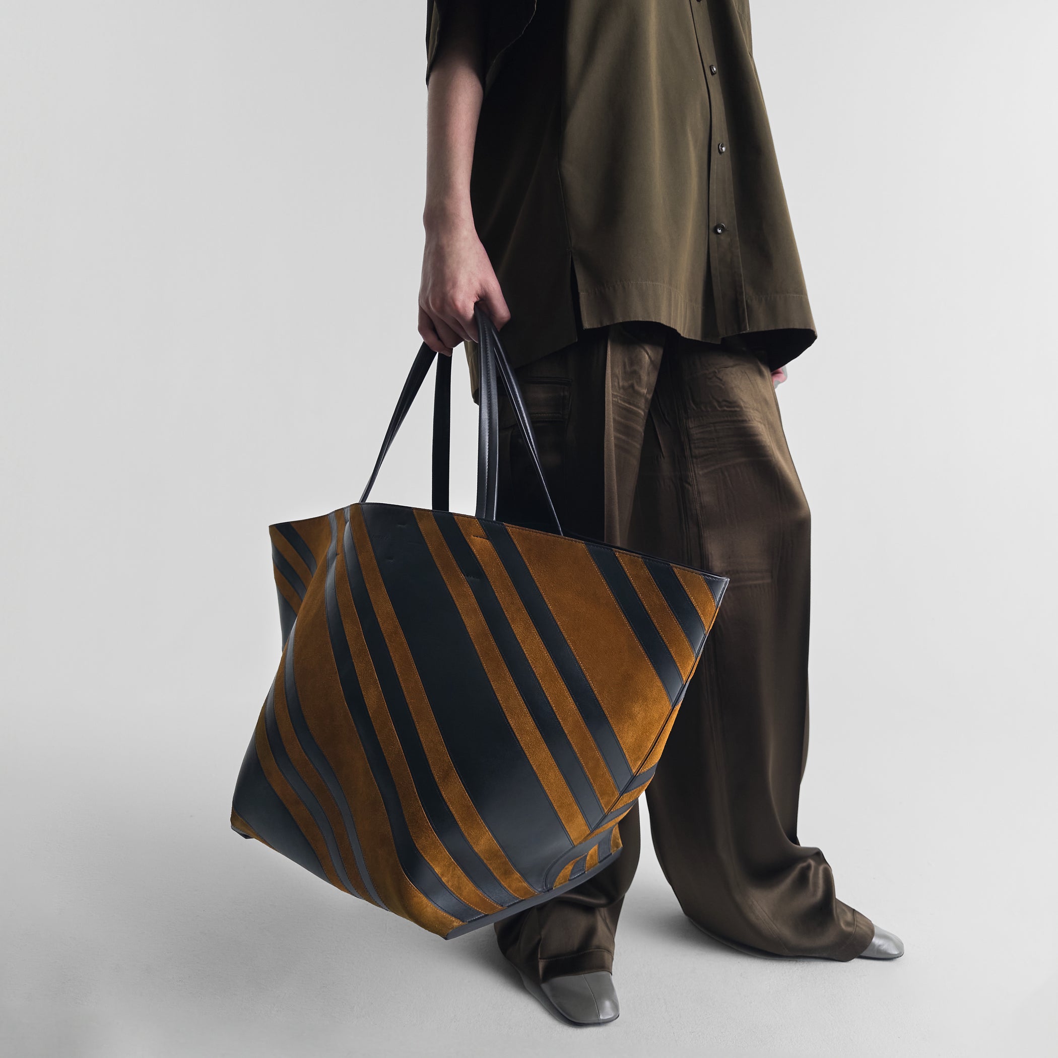 Model holding basket cabas in suede black-toffee.