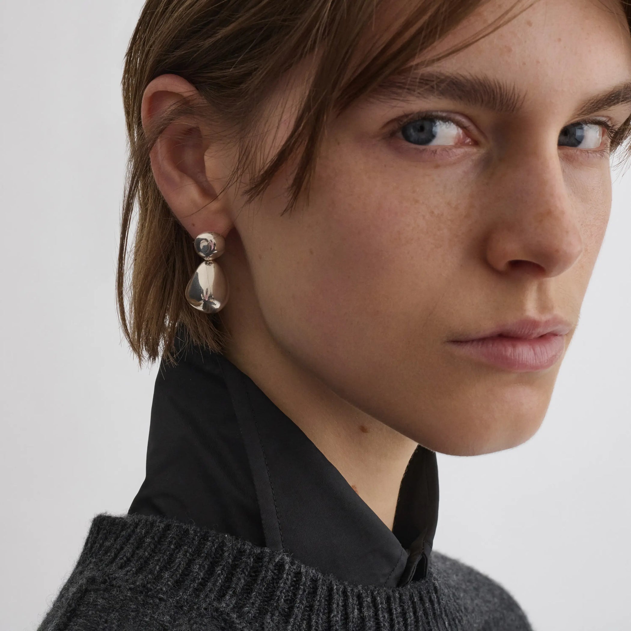 Side view of model wearing double ball earrings in sterling silver.
