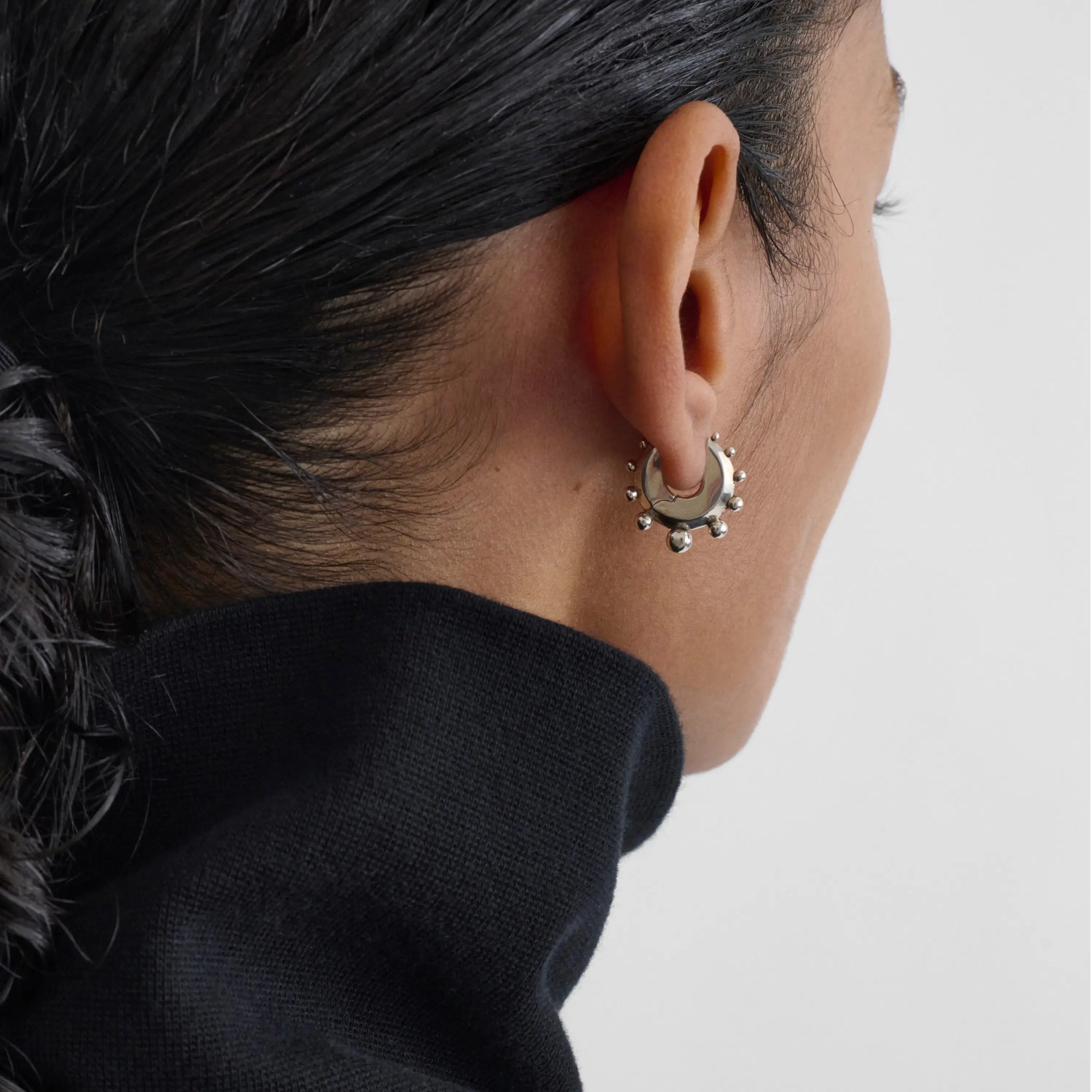 Back view of model wearing beaded hoop earrings small in sterling silver.
