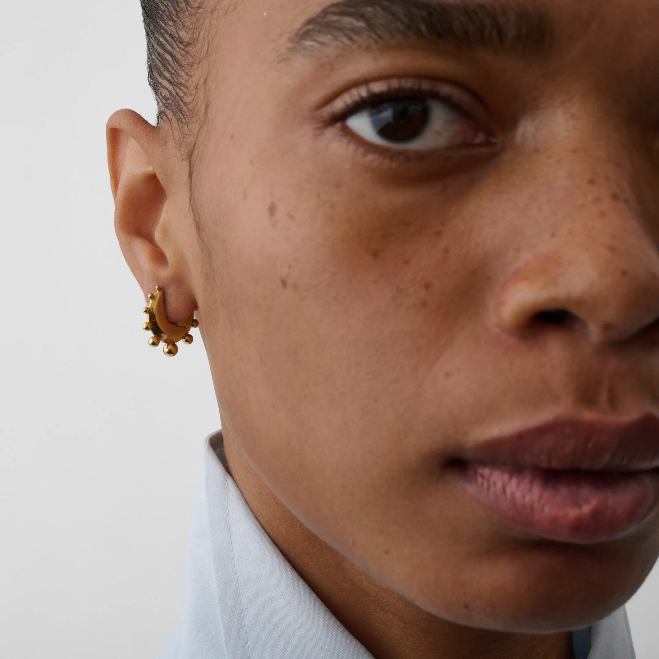 Front view of model wearing beaded hoop earrings small in gold plated sterling silver.