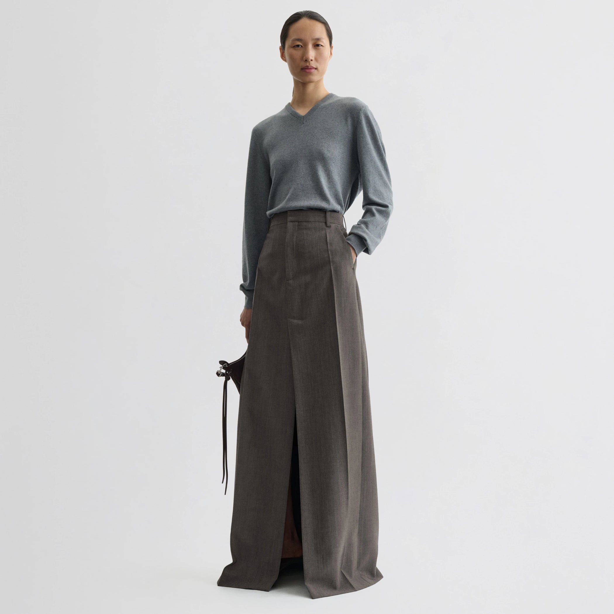 Front view of model wearing double slit tailored skirt in dark taupe wool.