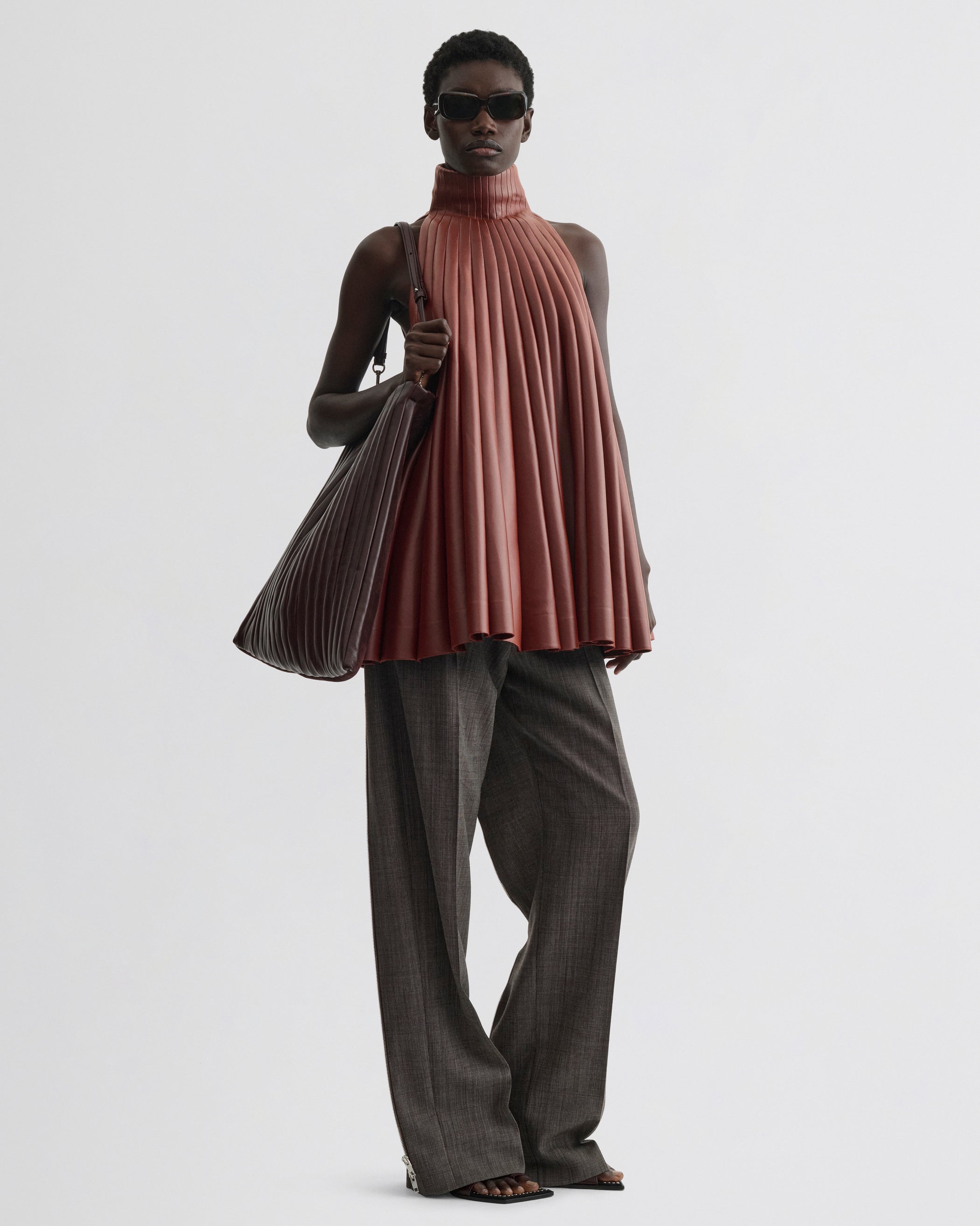 Front view of model wearing Accordion Top in brick bonded jersey