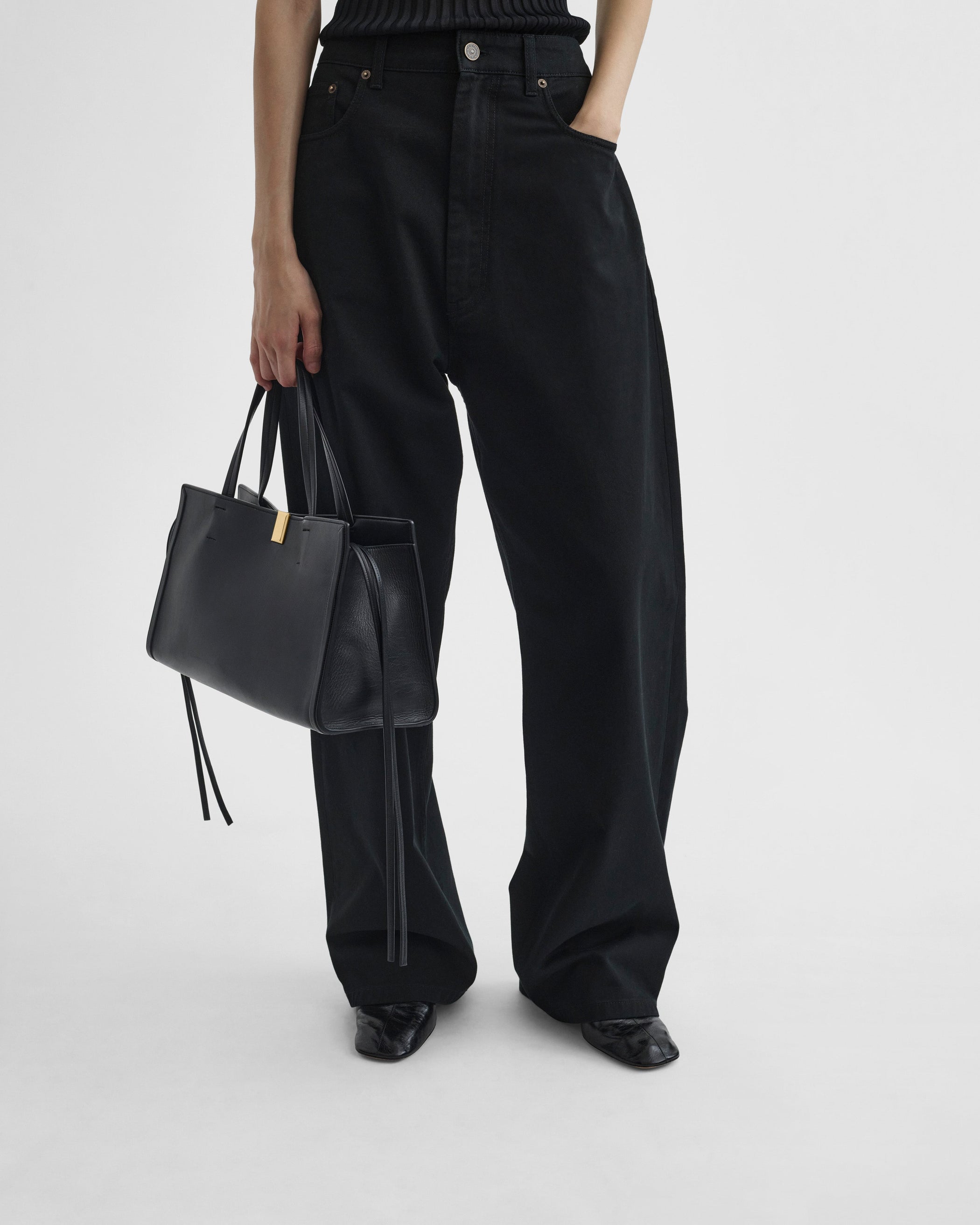 Model holding SMALL KIT CABAS in black leather with gold