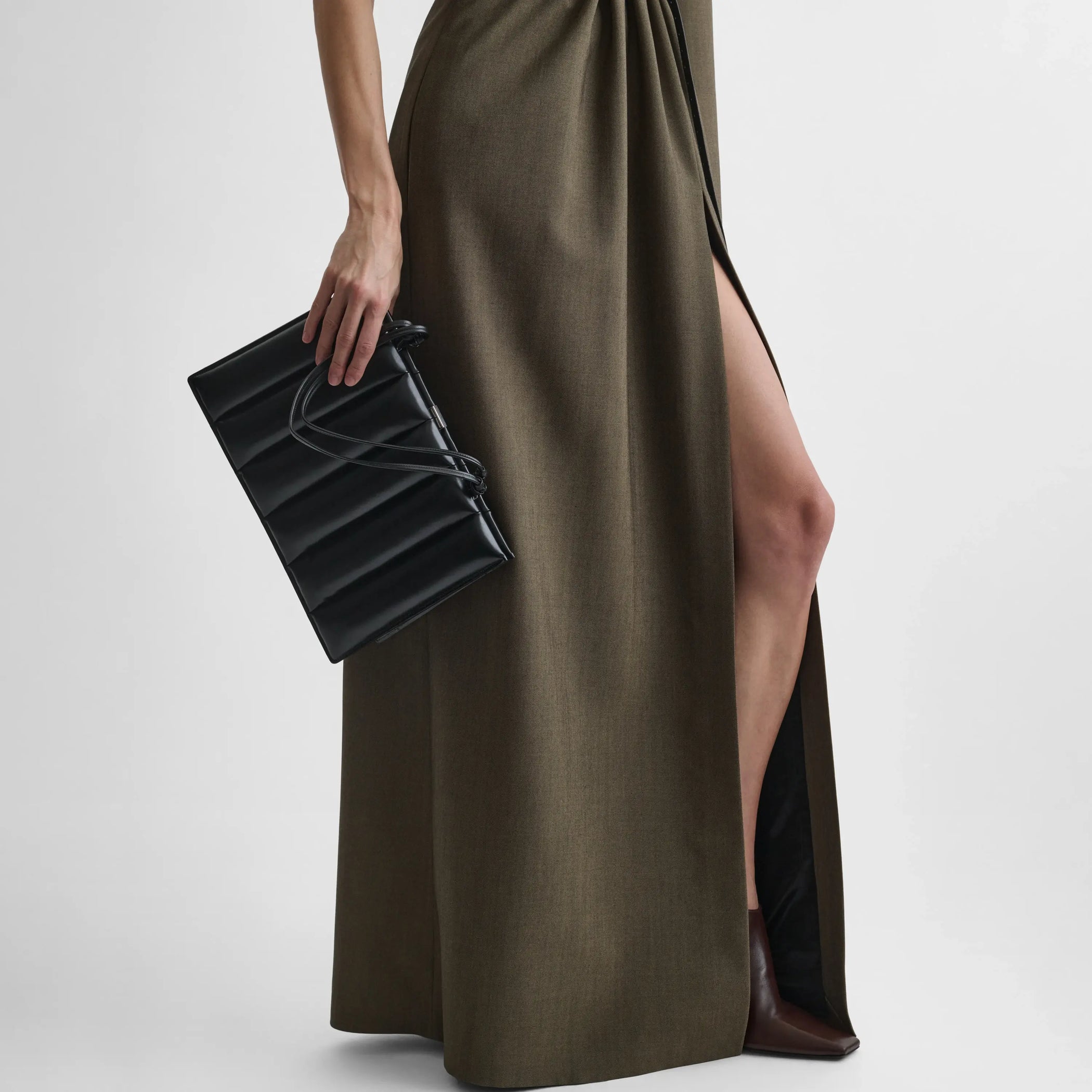Front view of model holding the drive bag in satin black calf 