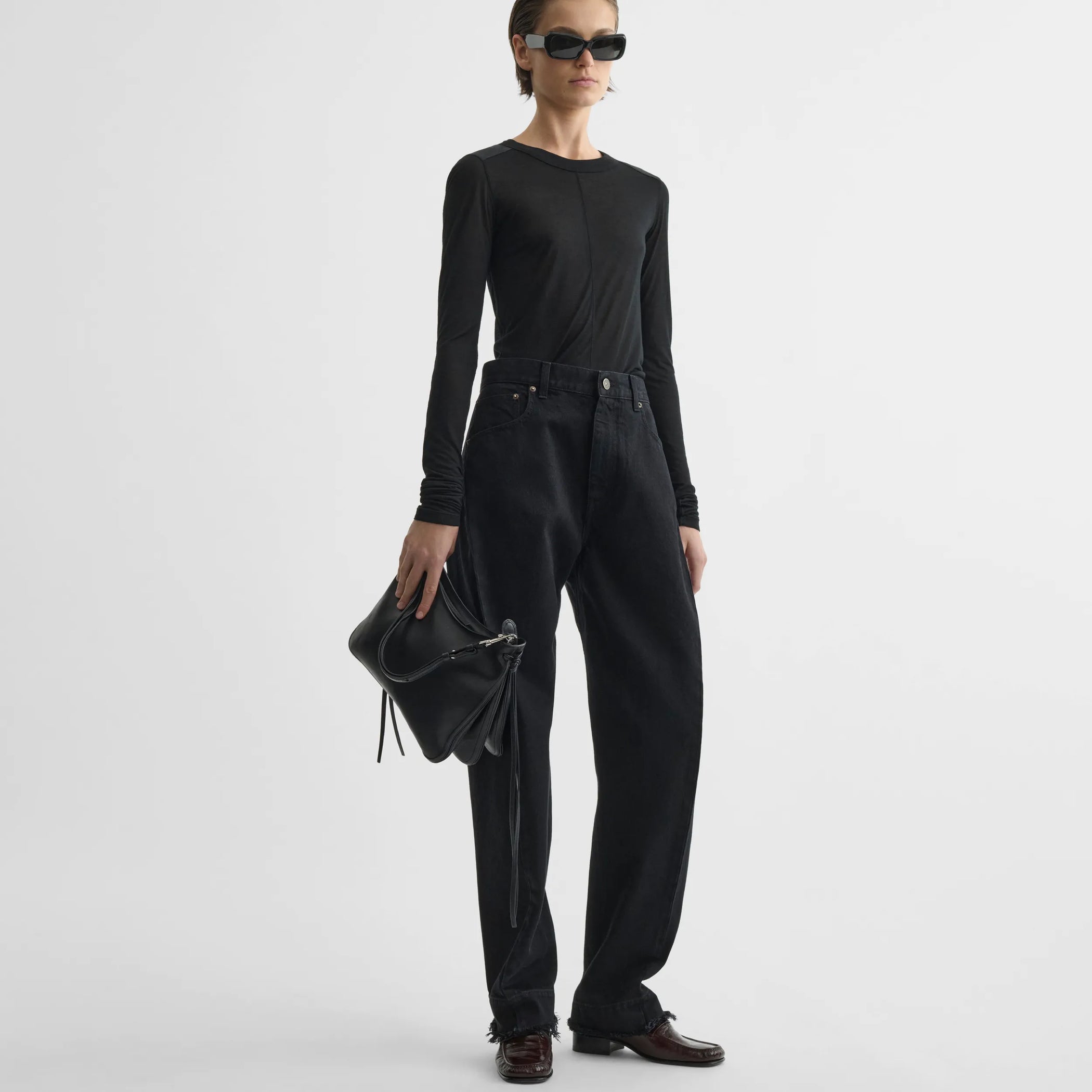 Front view of model holding gig bag in black leather.