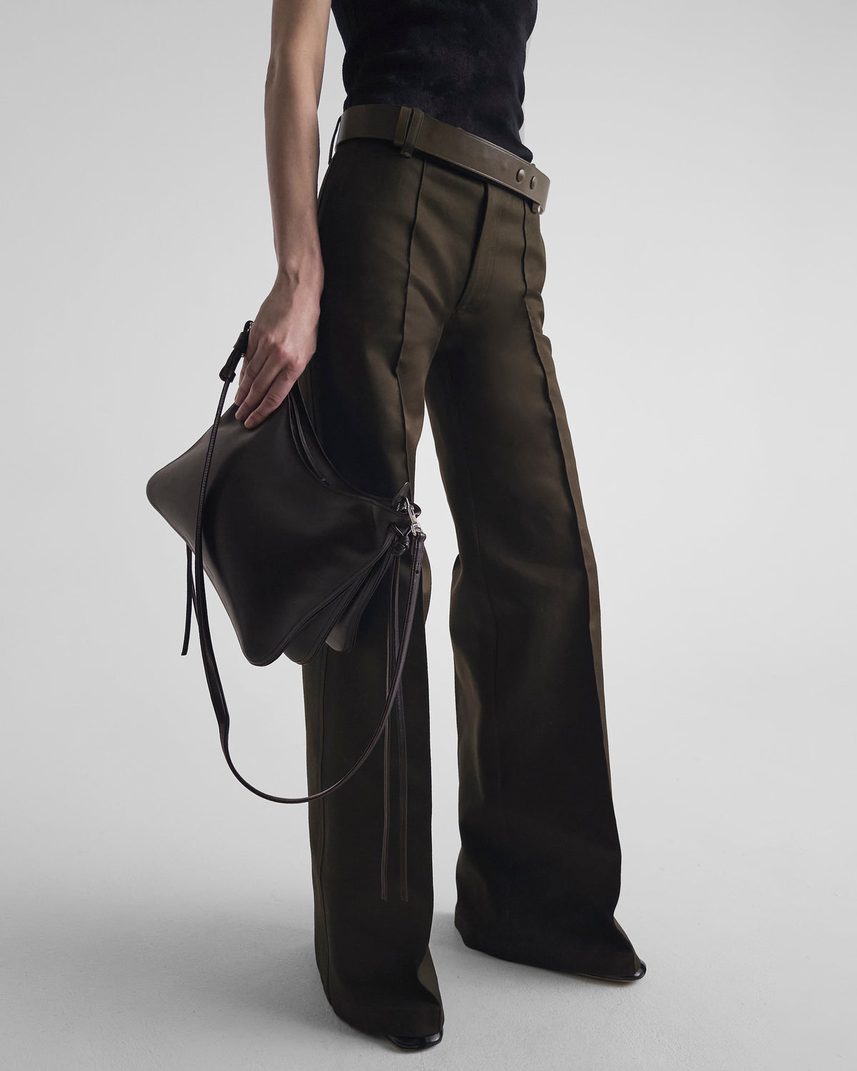 Front view of model holding GIG BAG in chocolate brown leather