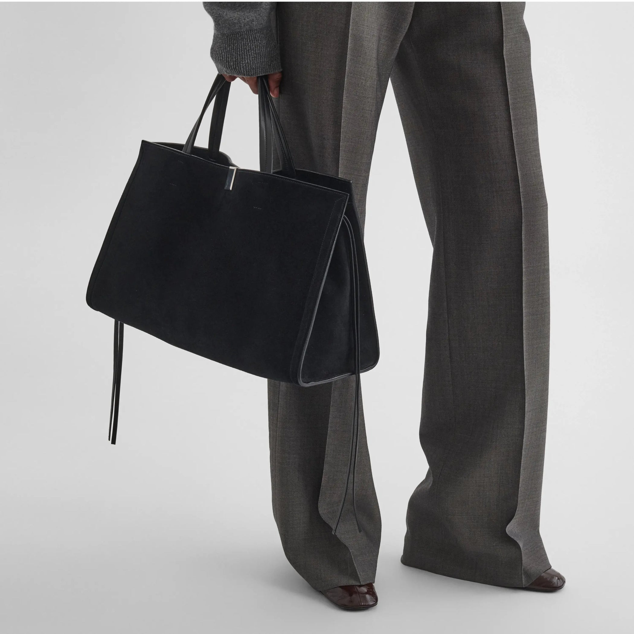 Front view of  model holding the medium kit cabas in suede black 