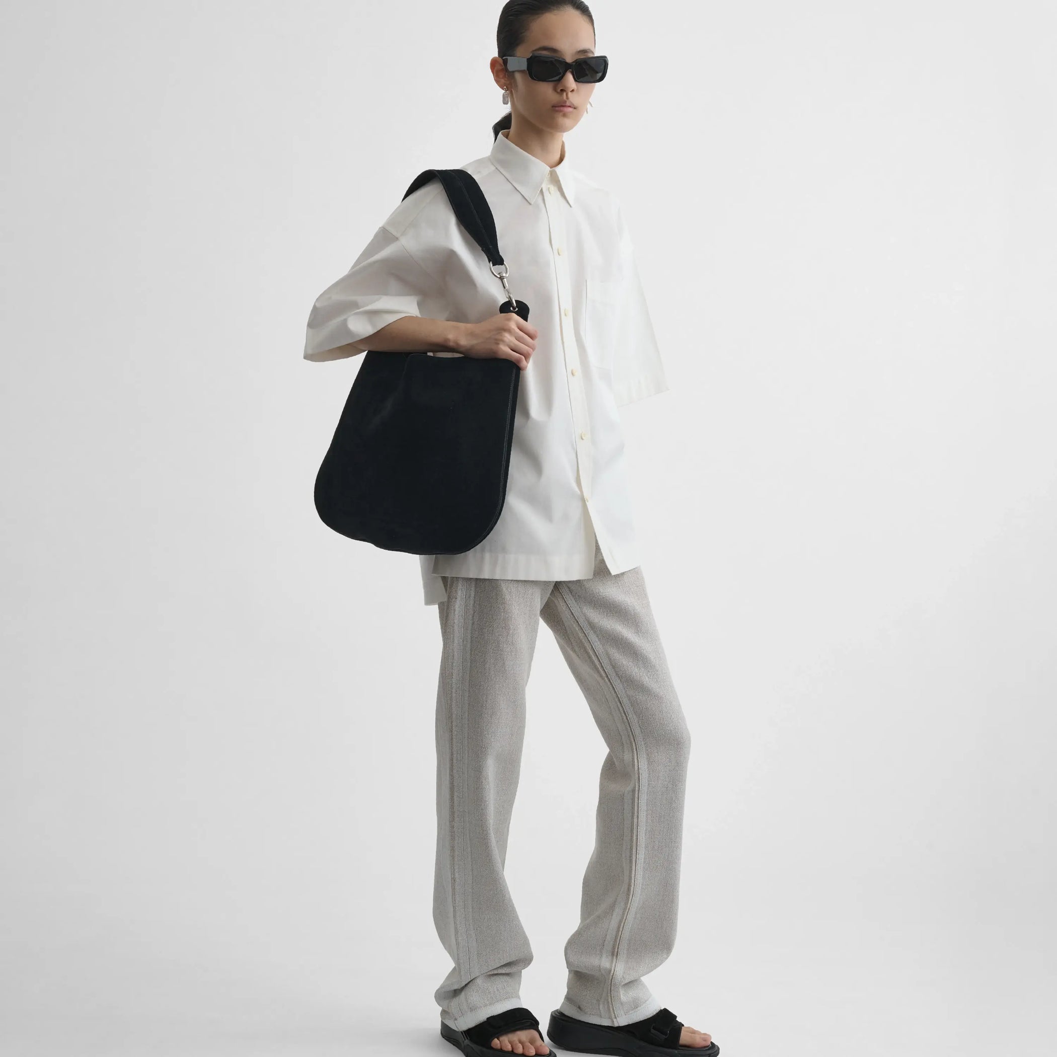 Front view of model wearing bean bag in suede black 