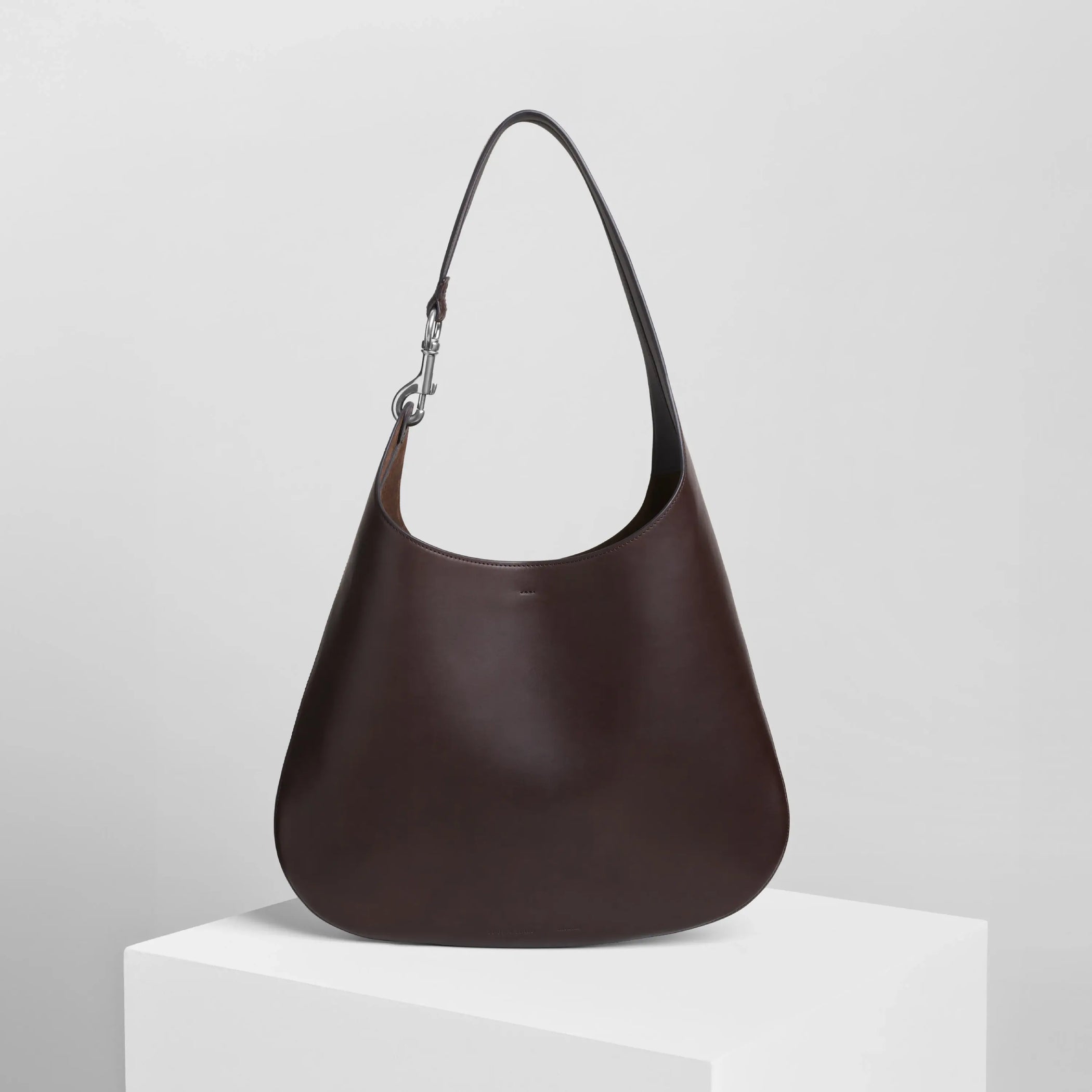 Front view of bean sling bag in chocolate brown leather.