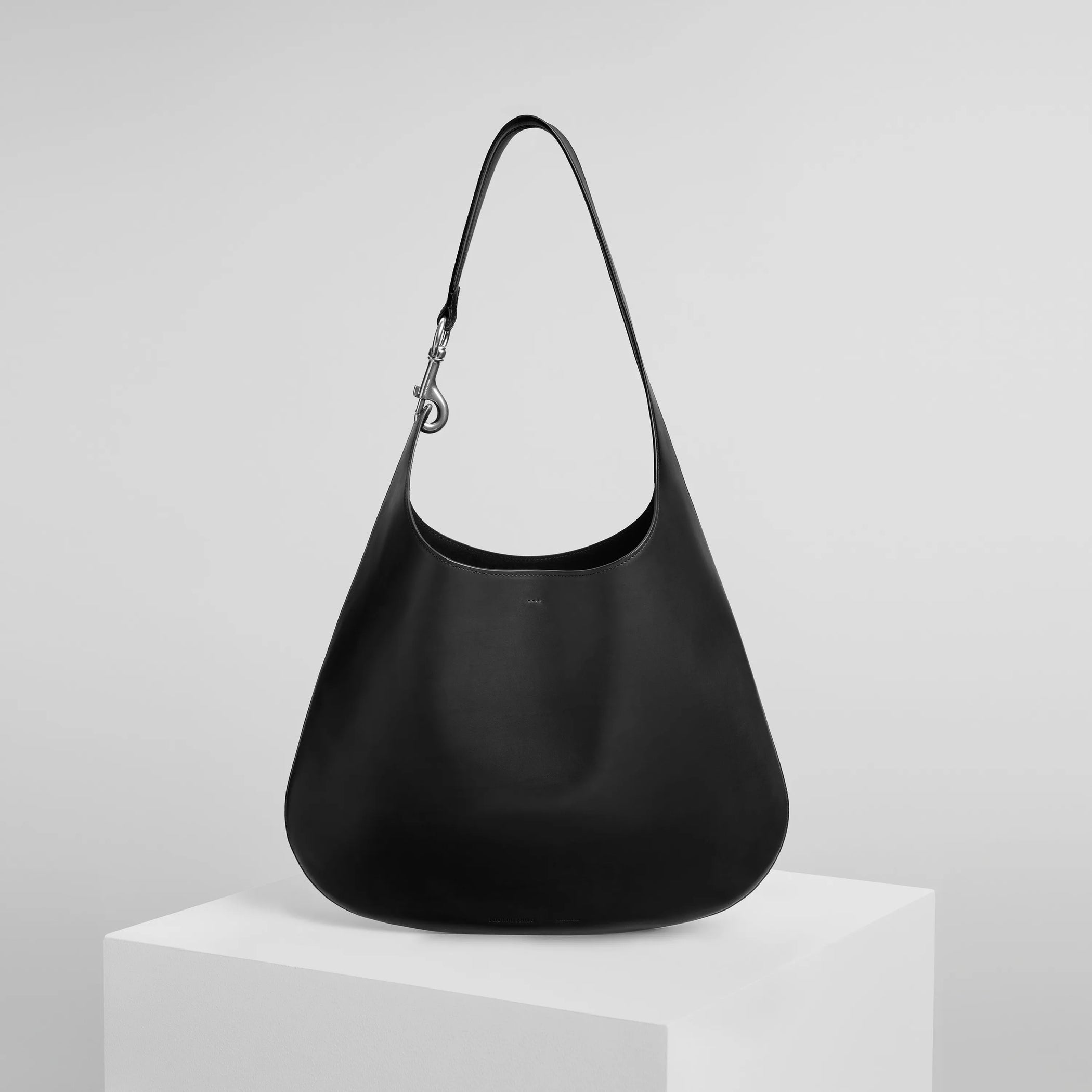 Front view of bean sling bag in black leather.