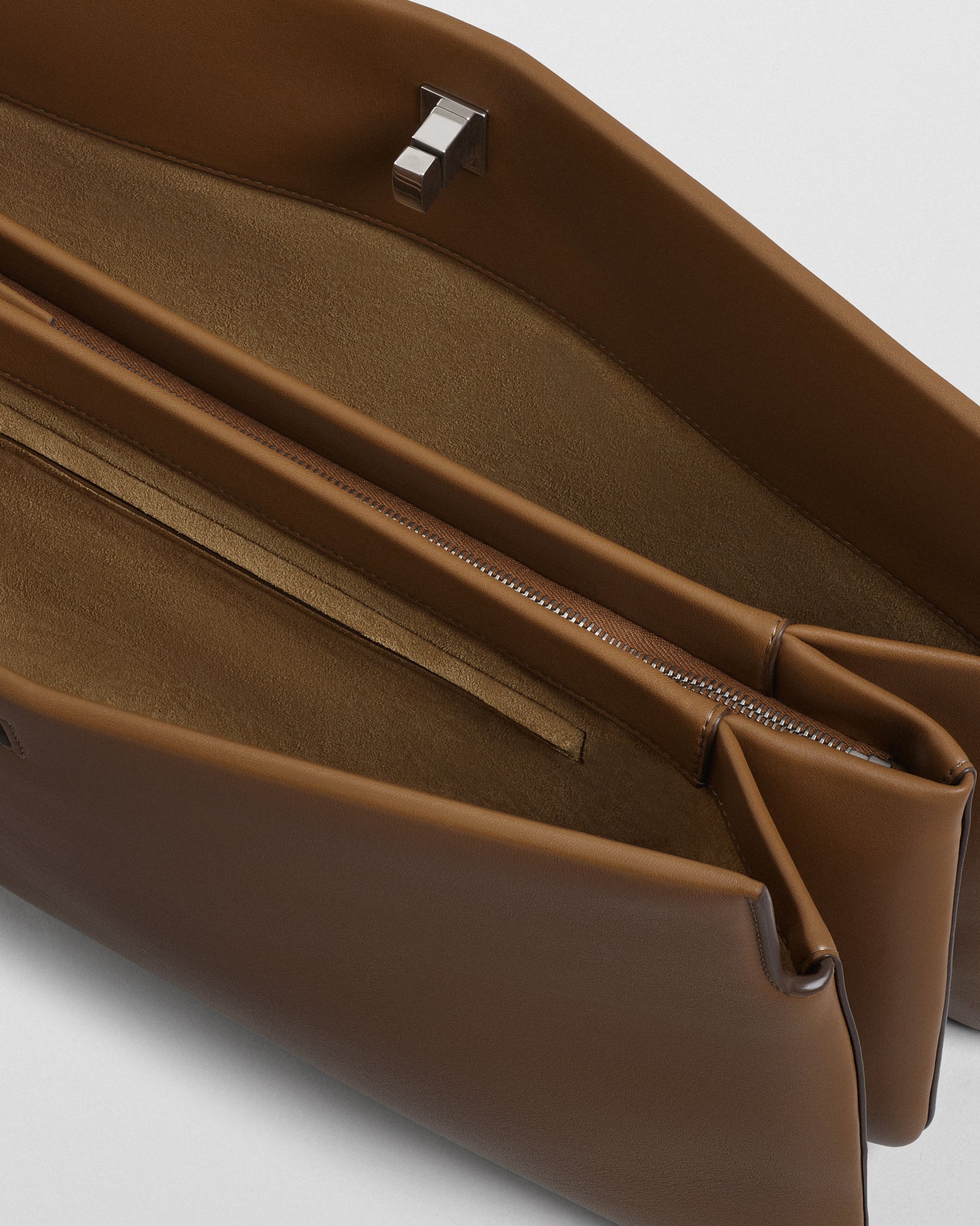 Close up open view of TRIPLEX CLUTCH in caramel leather.