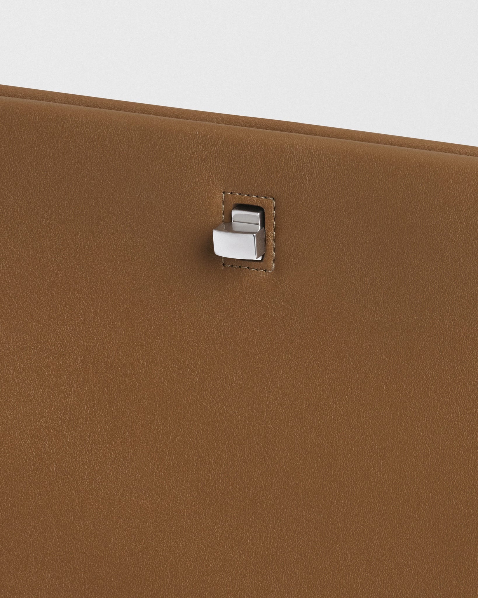 Close up detail view of TRIPLEX CLUTCH in caramel leather.