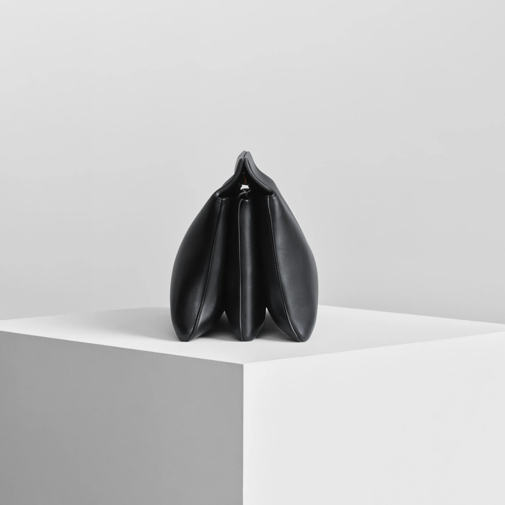Side view of triplex clutch in black leather with gold.