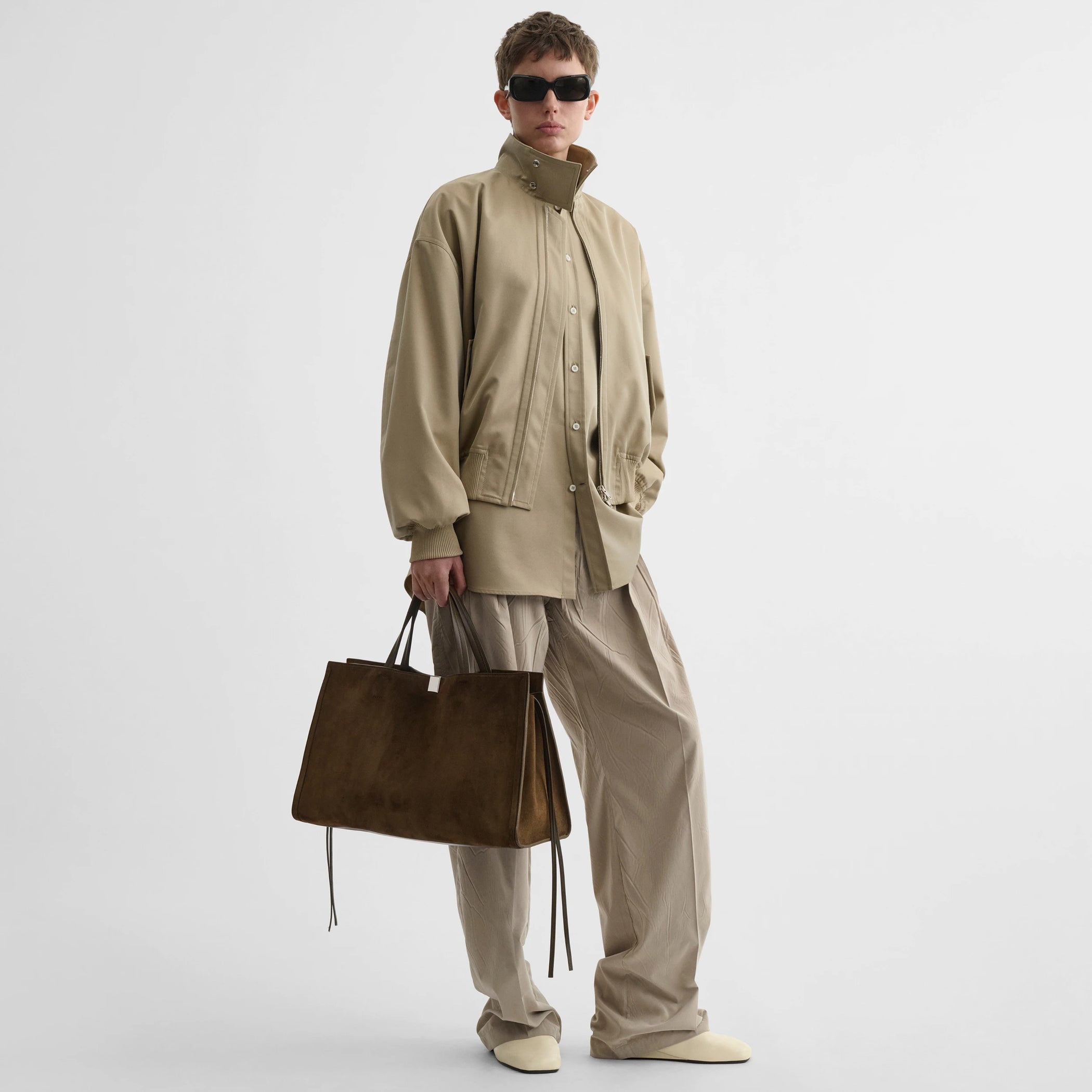 Front view of model wearing medium kit cabas in khaki suede leather.