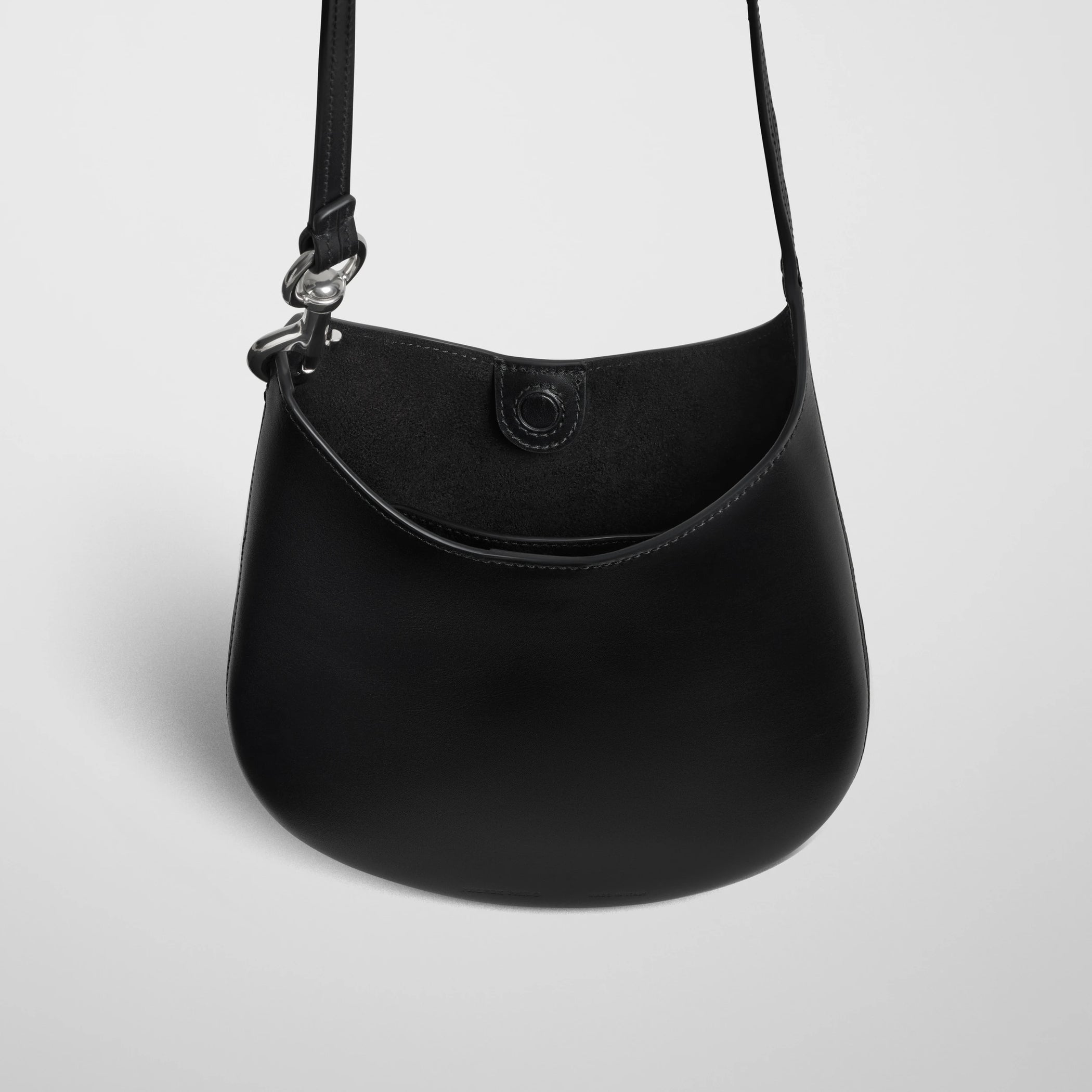 Close up detail view of mini bean sling in black leather.