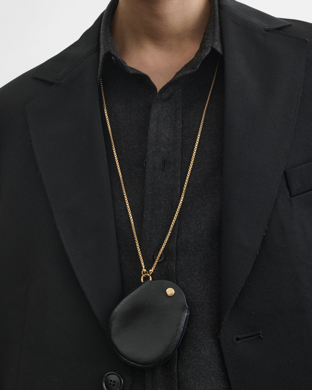 View of model wearing POUCH PENDANT in black leather