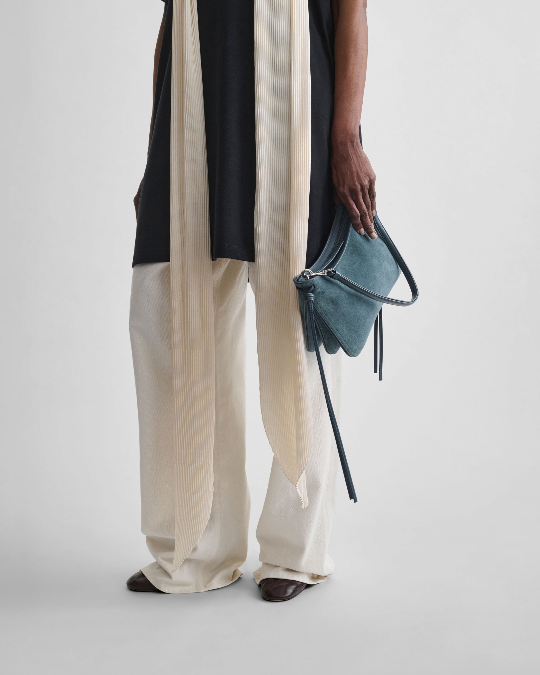 View of model holding SMALL GIG BAG in denim blue suede