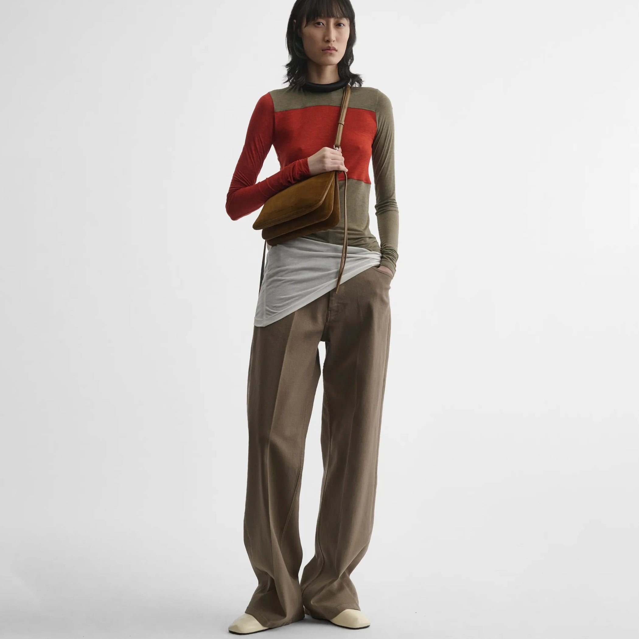 Front view of model holding small gig in toffee suede.