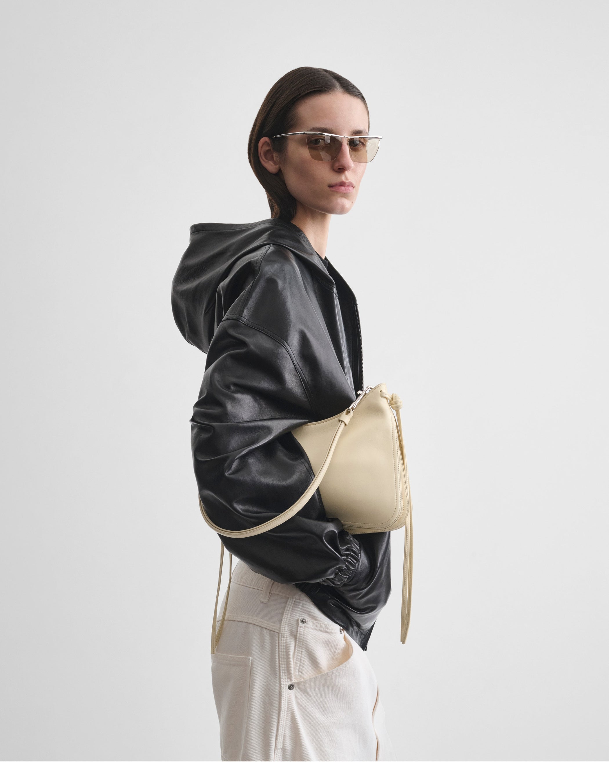 Model holding SMALL GIG BAG in stucco leather