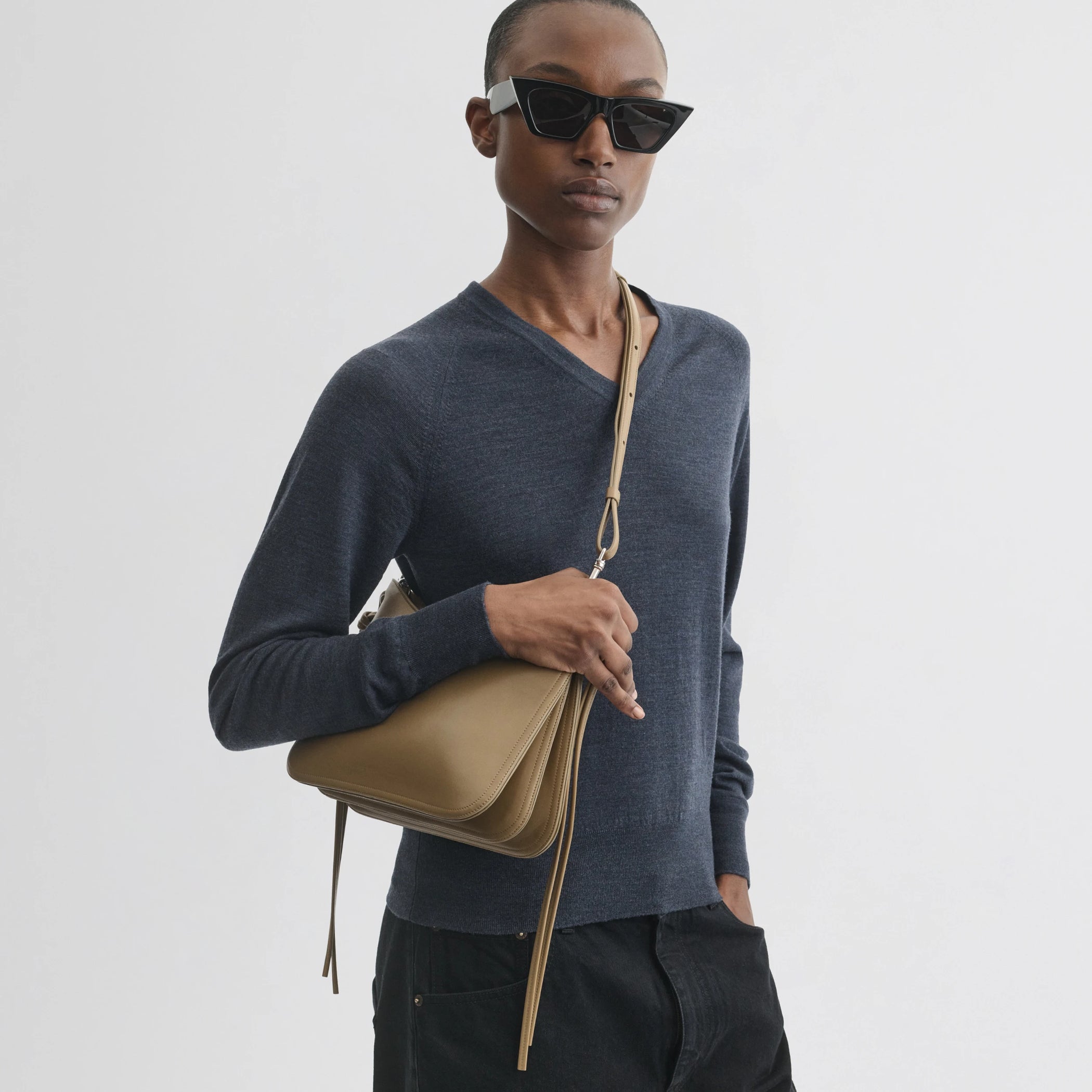 Front view of model wearing small gig bag in cookie leather.