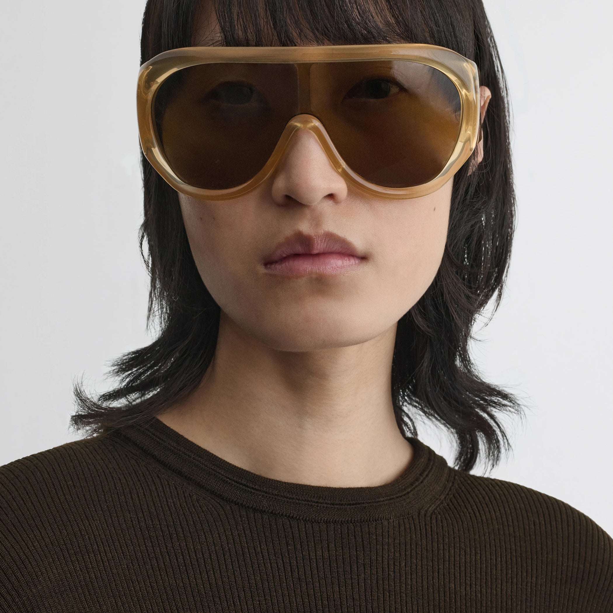 Front view of model wearing bombé sunglasses in caramel acetate.