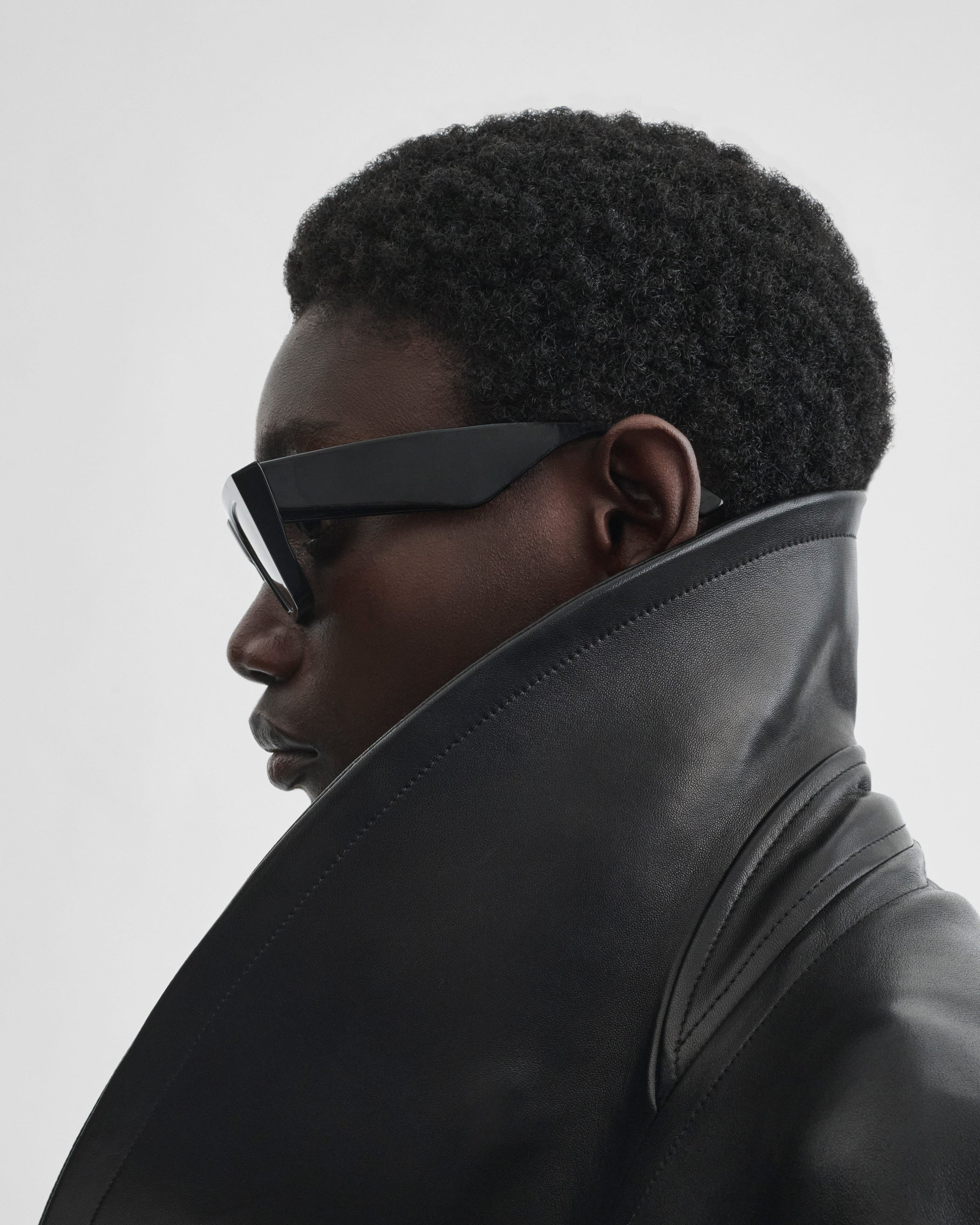 Side view of model wearing PEAK SUNGLASSES in black acetate