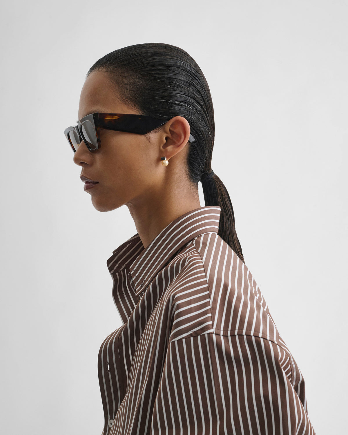 Side view of model wearing PEAK SUNGLASSES in cognac tortoiseshell acetate