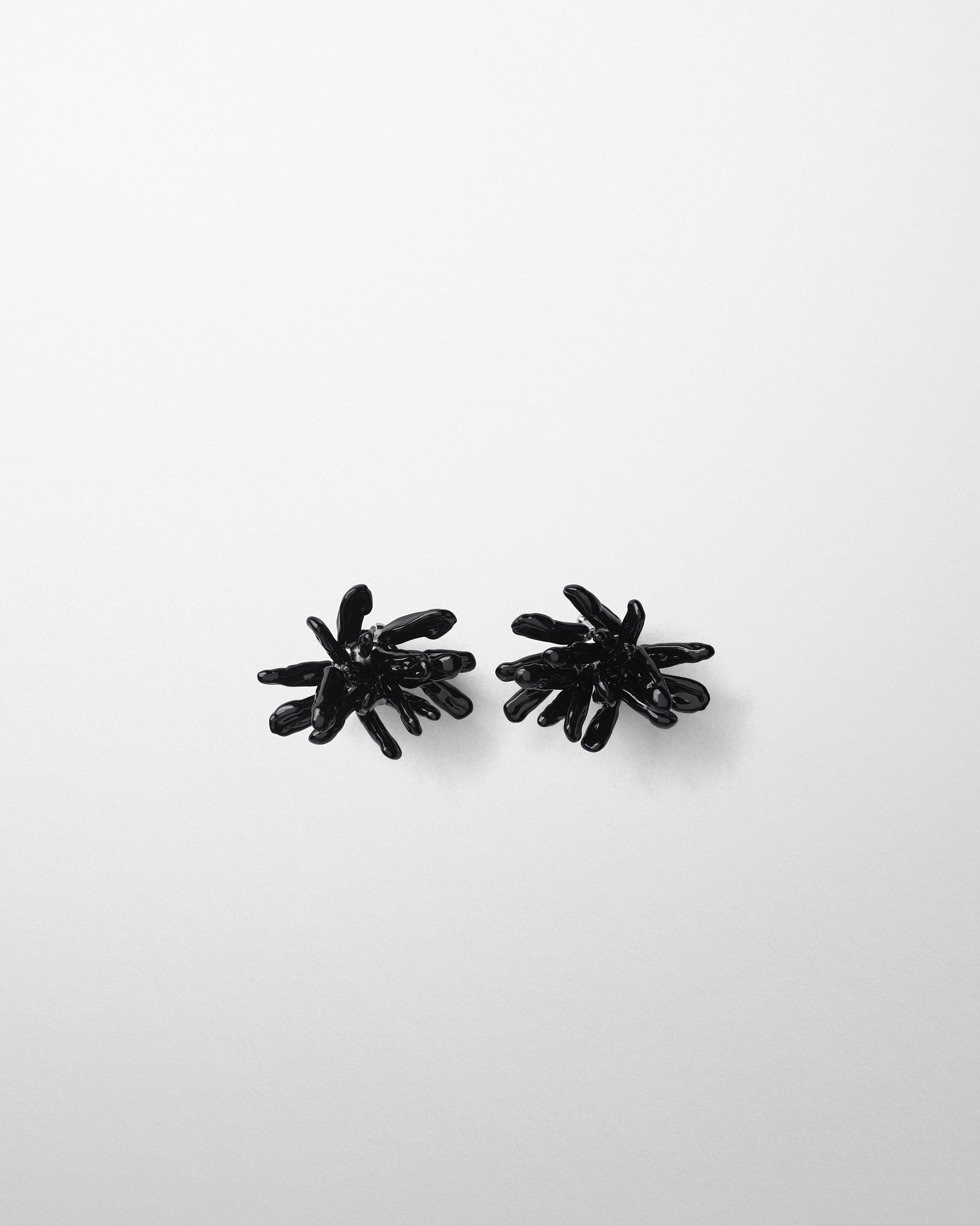 Flat front view of CLUSTER EARRINGS in black resin