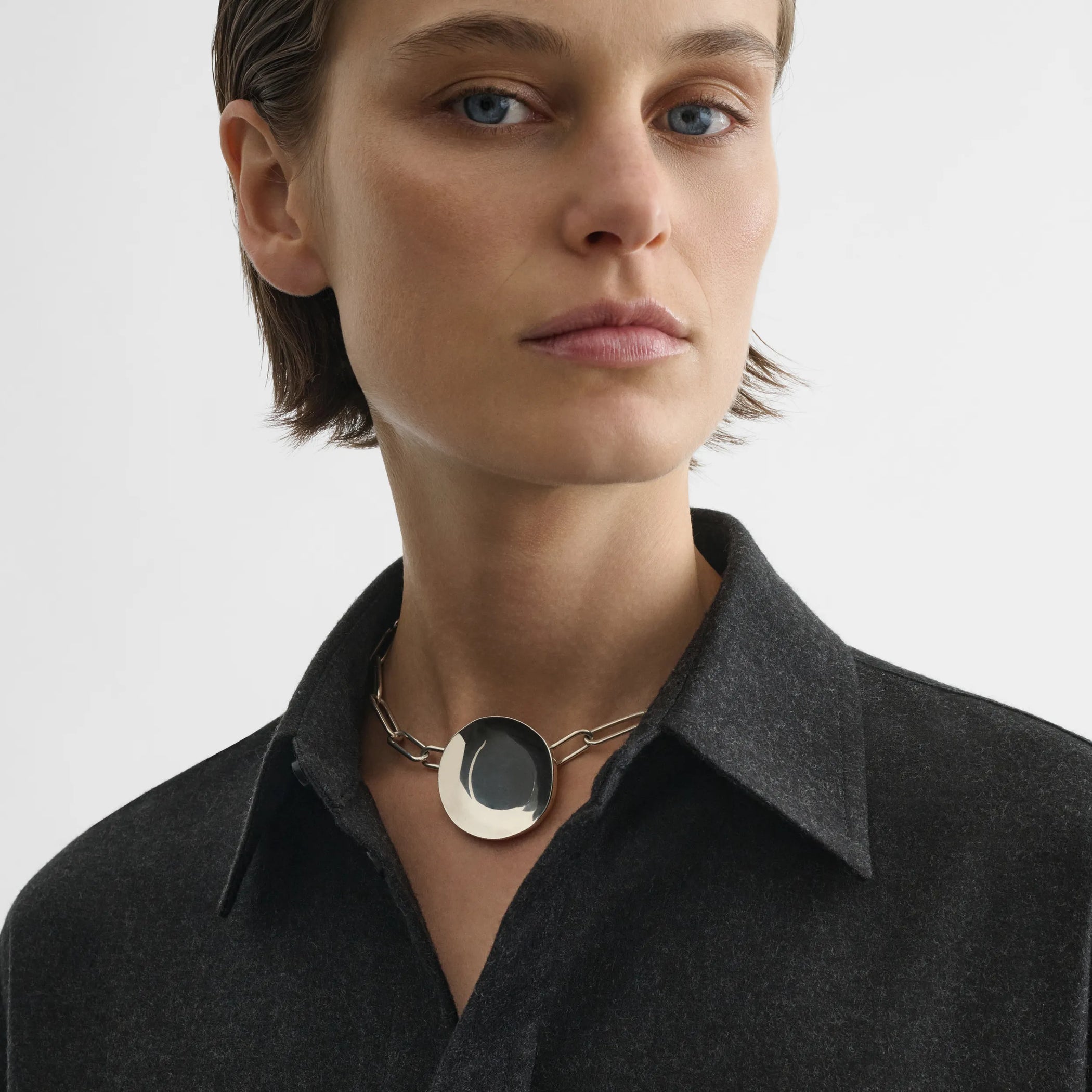 Front view of model wearing medallion necklace in sterling silver.