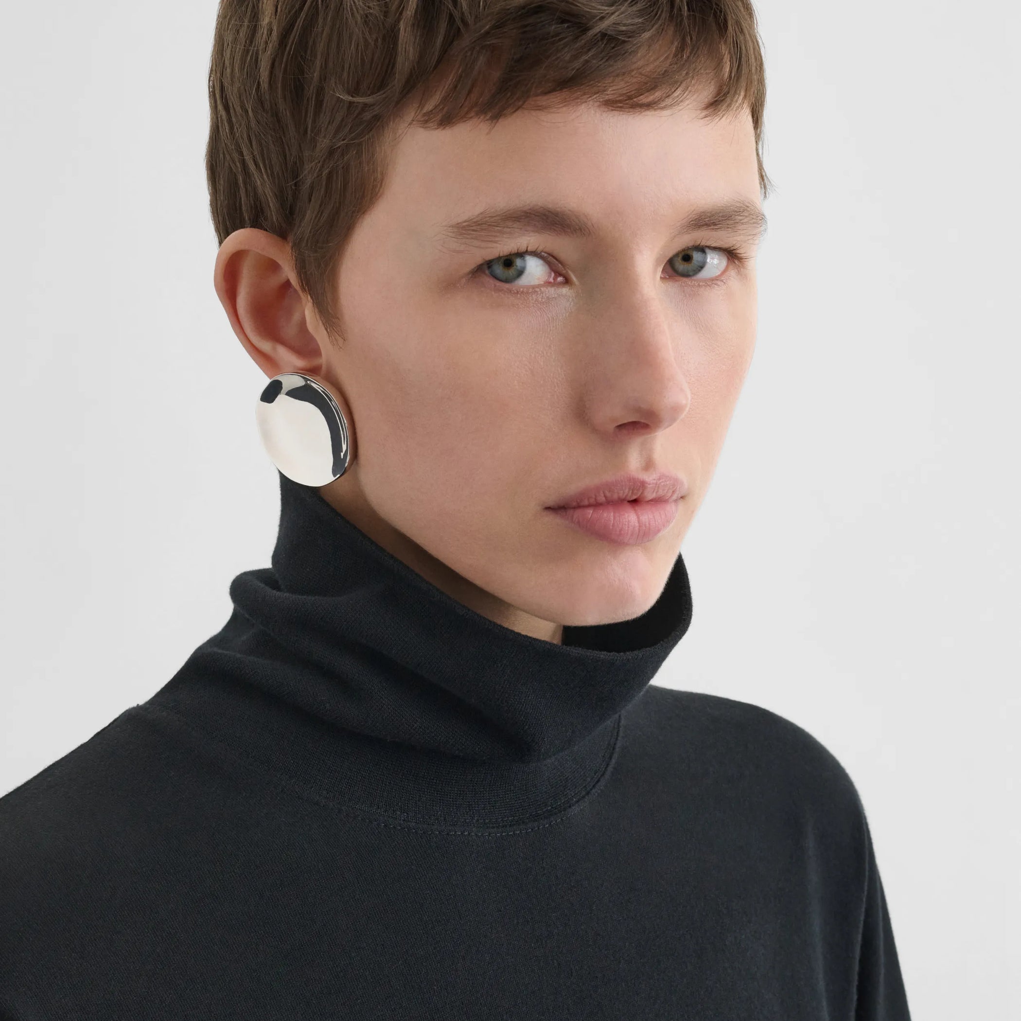 Front view of model wearing medallion dish earrings in sterling silver.