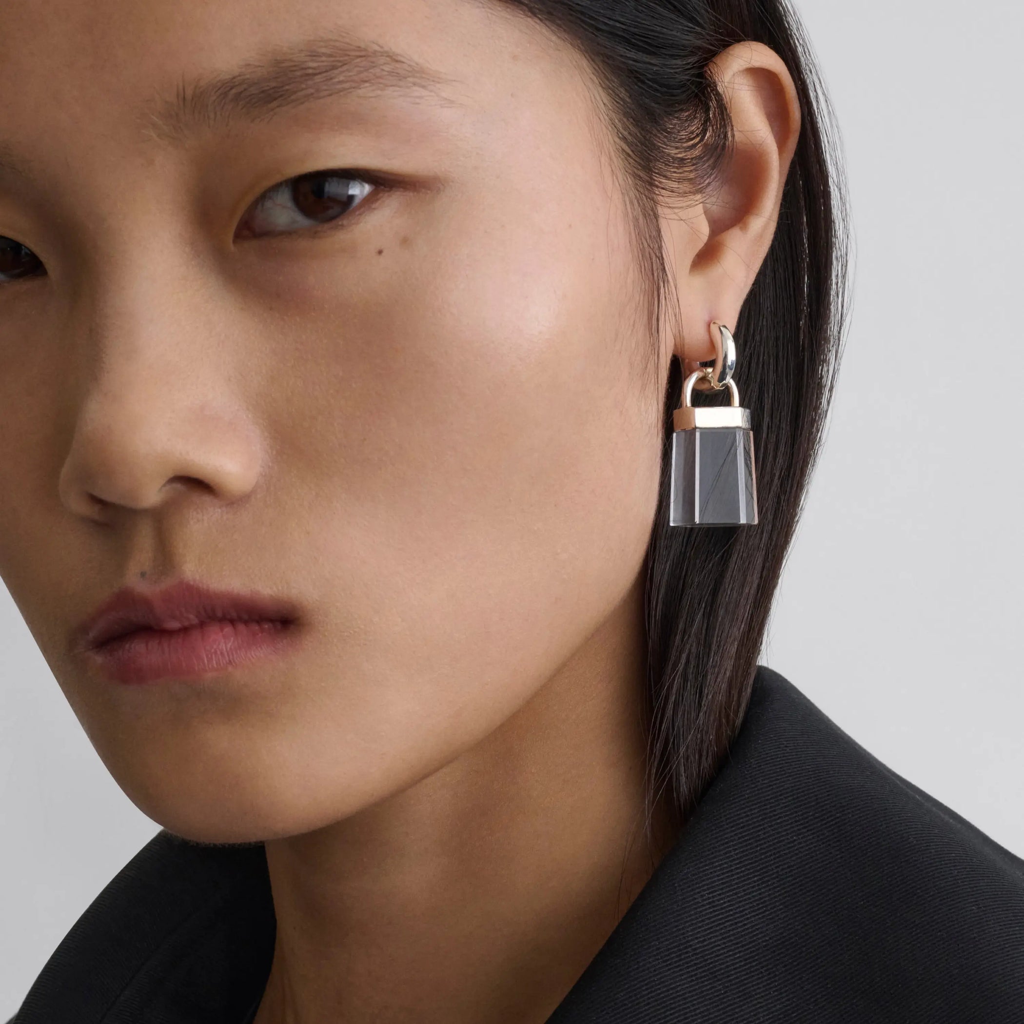 Model wearing prism earrings in clear resin. 