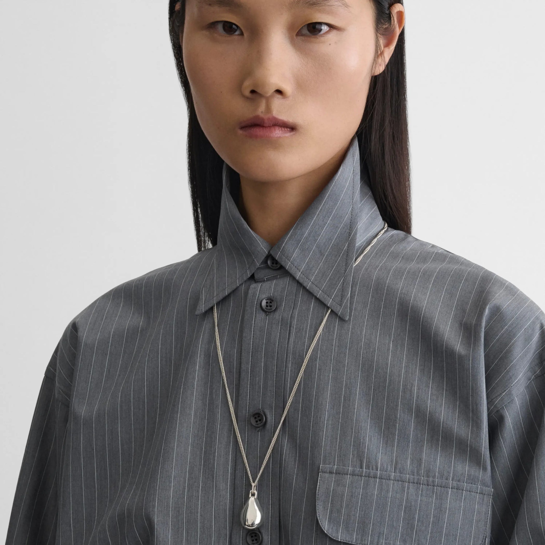 Model wearing small pebble pendant in sliver 