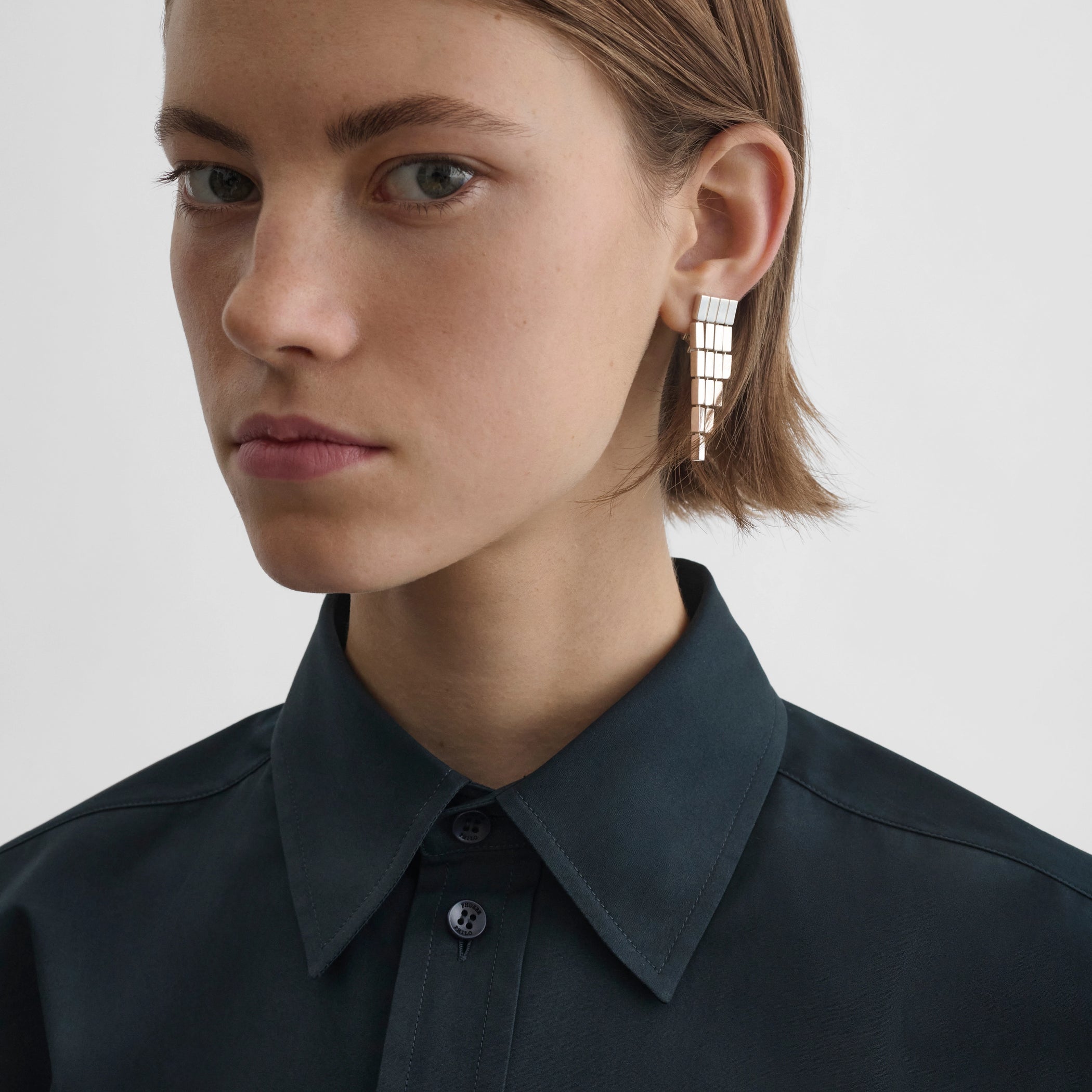 Front view of model wearing geometric cascade earrings in sterling silver 