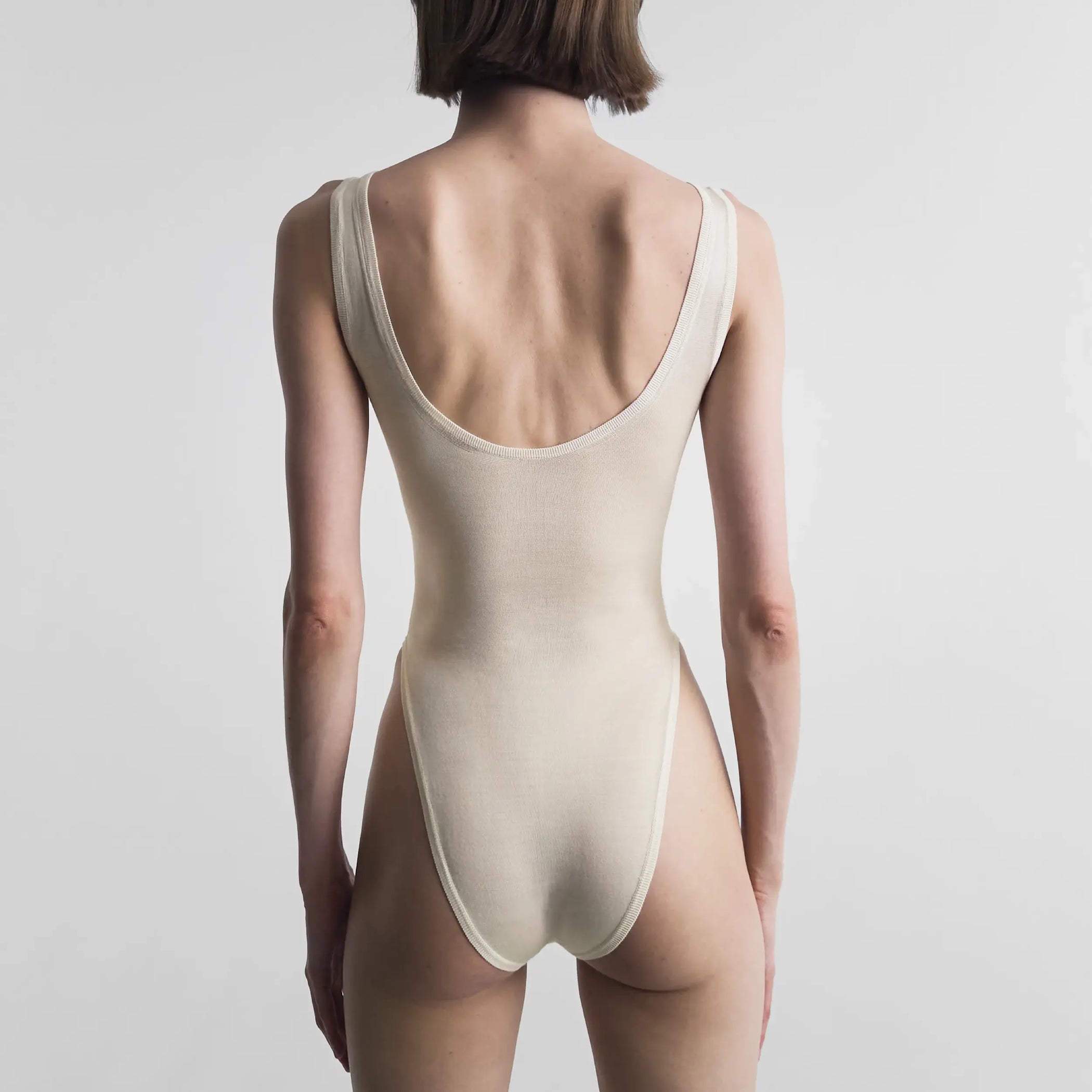 Back view of model wearing BODY in off white silk