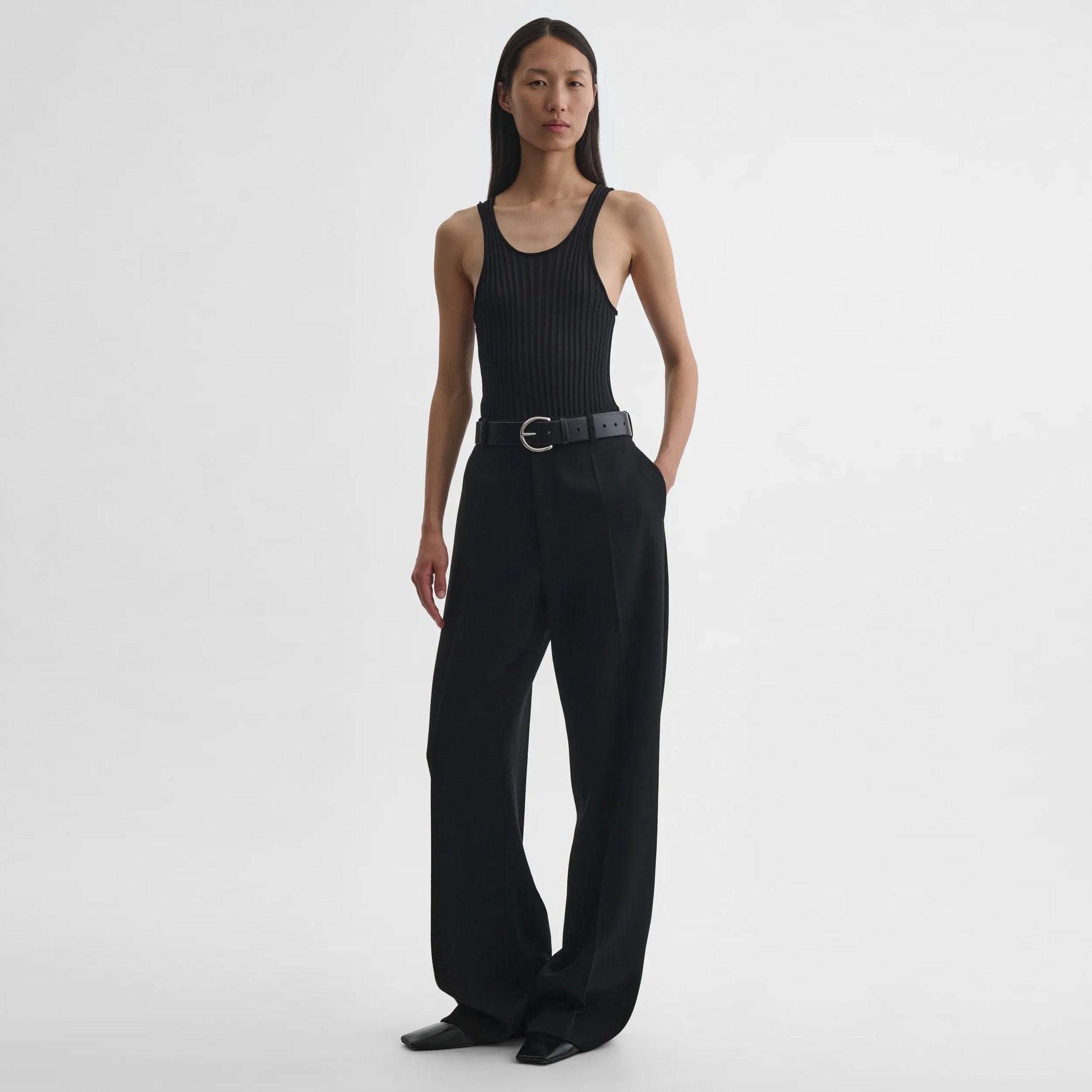 Front full body view of model wearing milanese trousers in black wool.