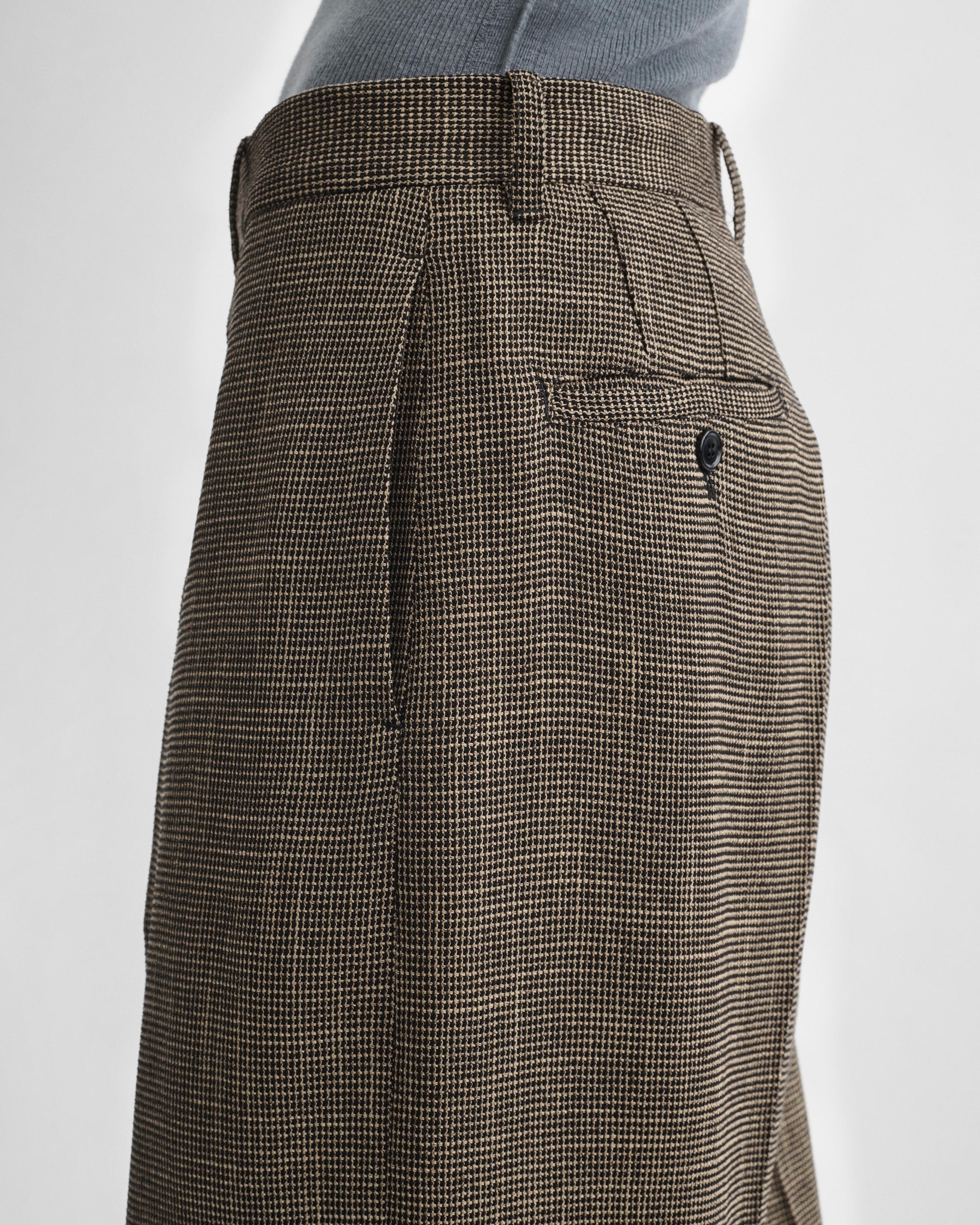 Detail side view of model wearing DROP TROUSERS in salt and pepper melange woven viscose