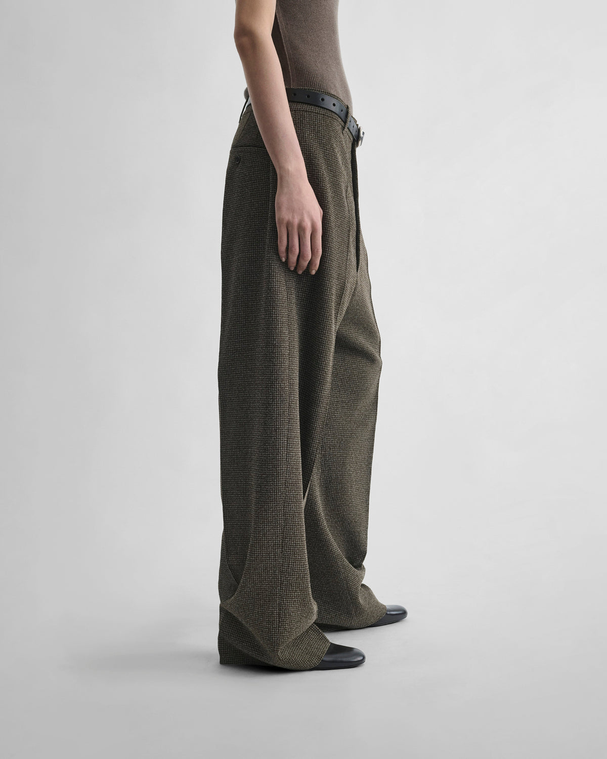 Side view of model wearing DROP TROUSERS in khaki/white wool