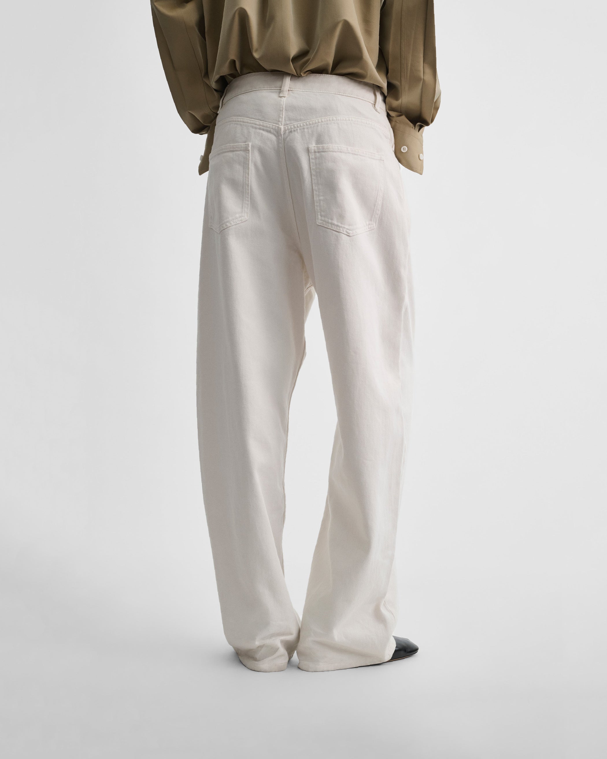 Back view of model wearing DROP JEANS in chewing gum cotton