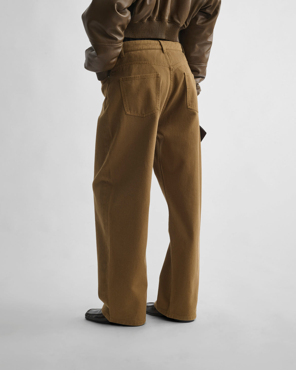 Back view of model wearing DROP JEANS in tobacco cotton