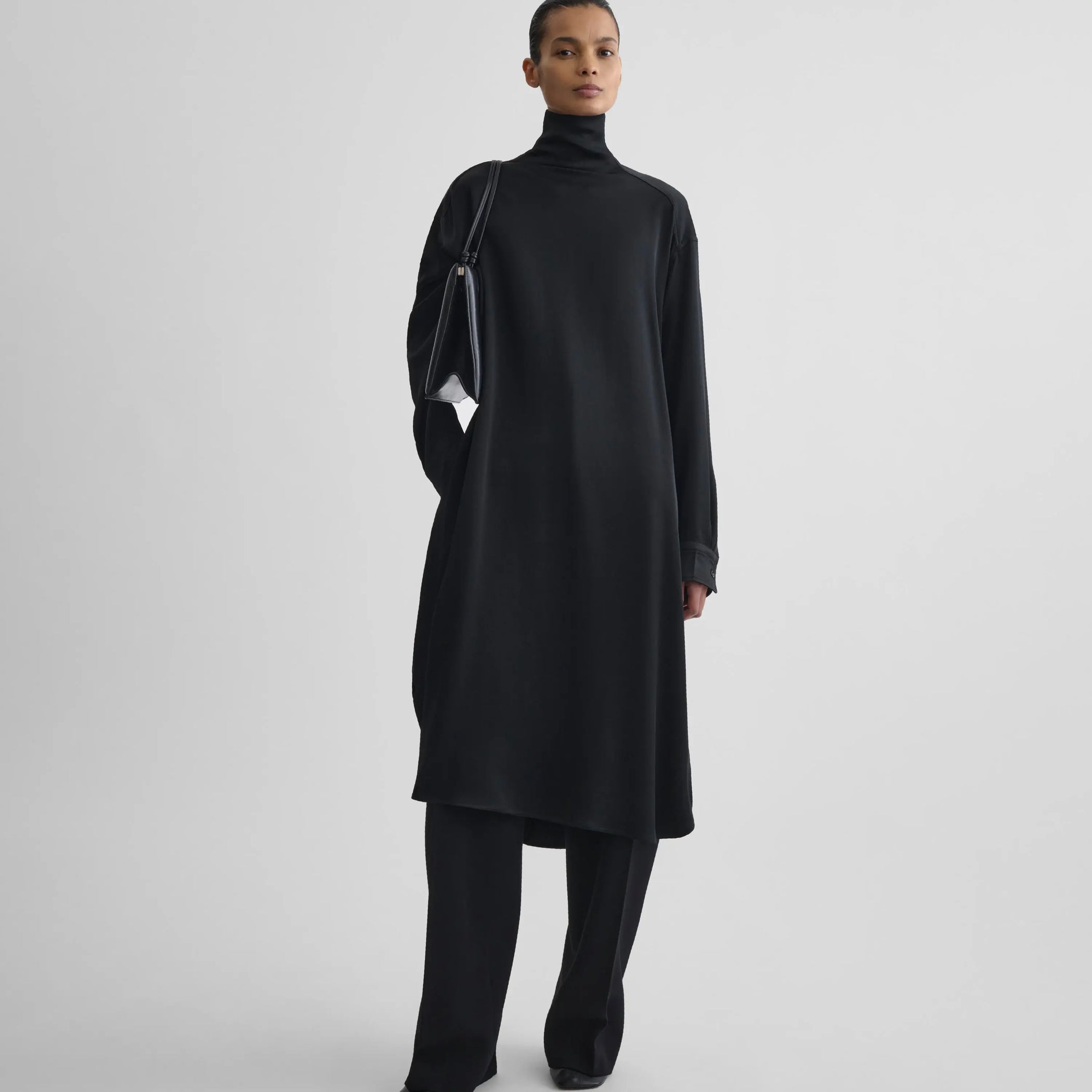 Front full body view of model wearing dress in black satin-back crepe.