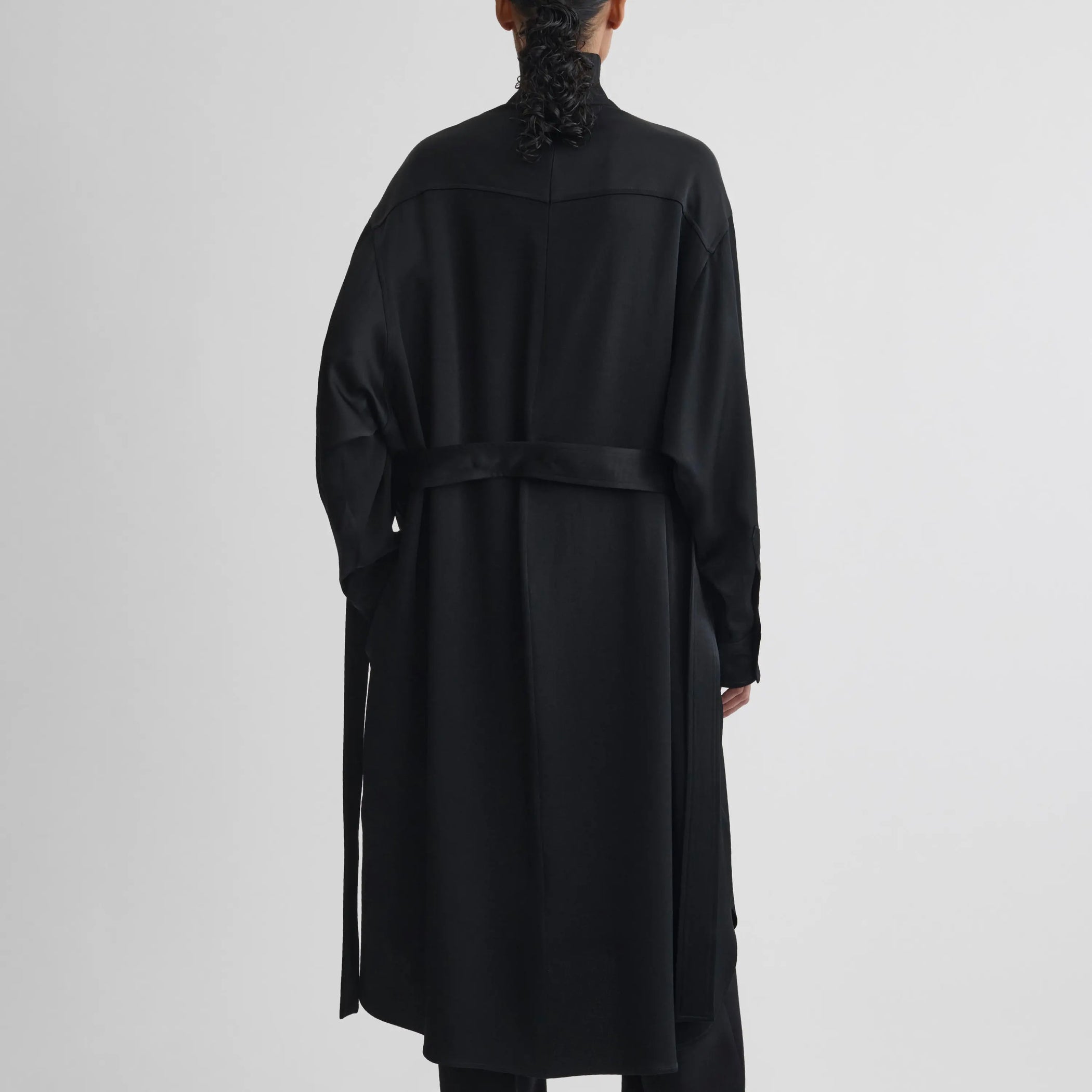 Back view of model wearing dress in black satin-back crepe.