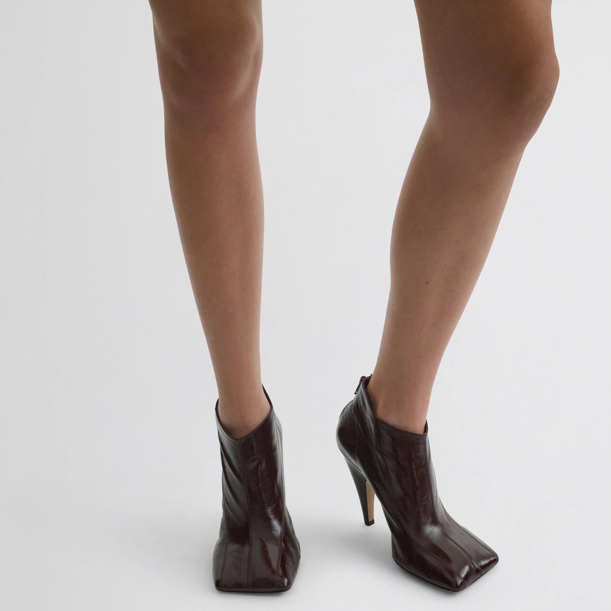 Front view of model wearing tilt ankle boot in oxblood leather.