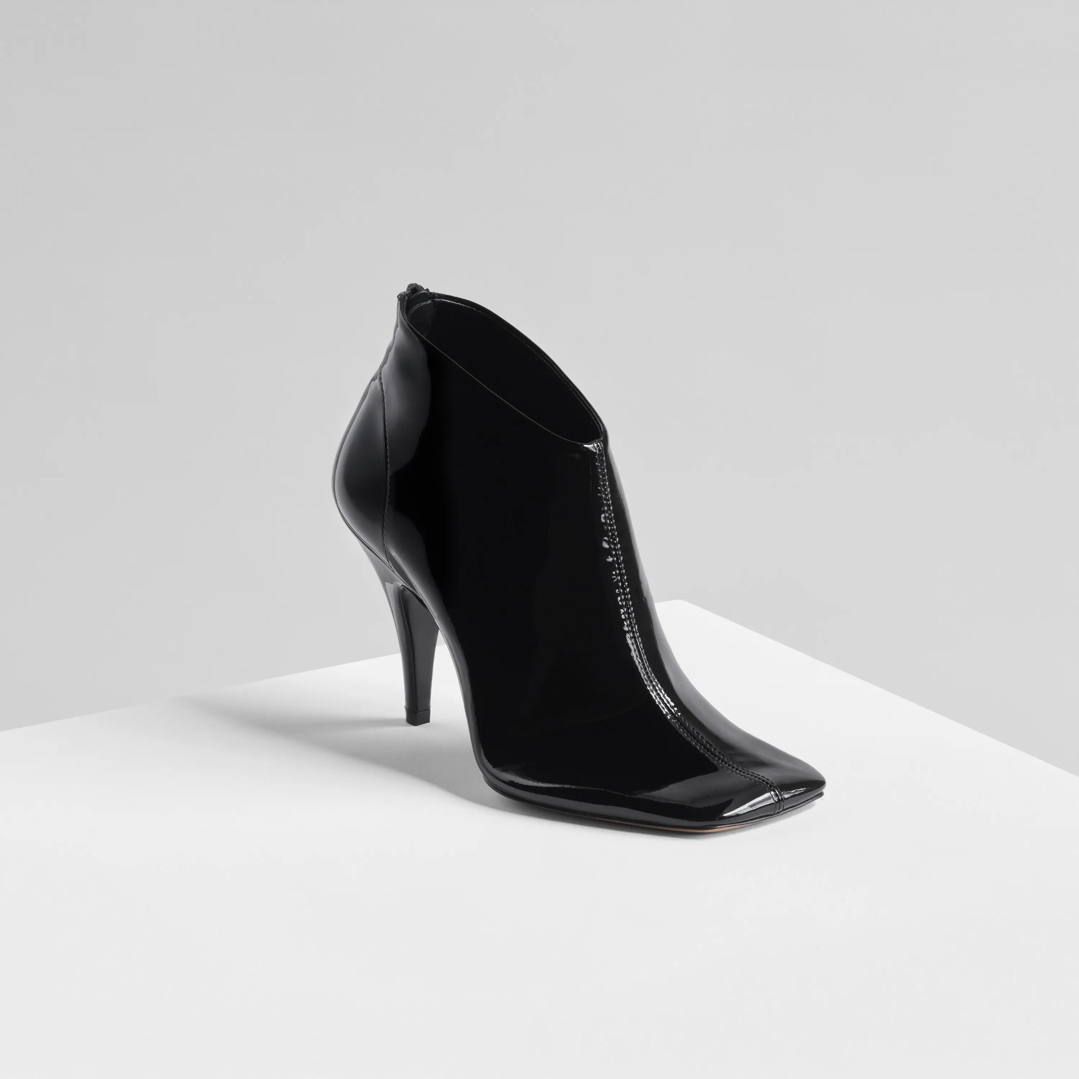 Angled front view of Soft Ankle Boot 90 in glossy black. 