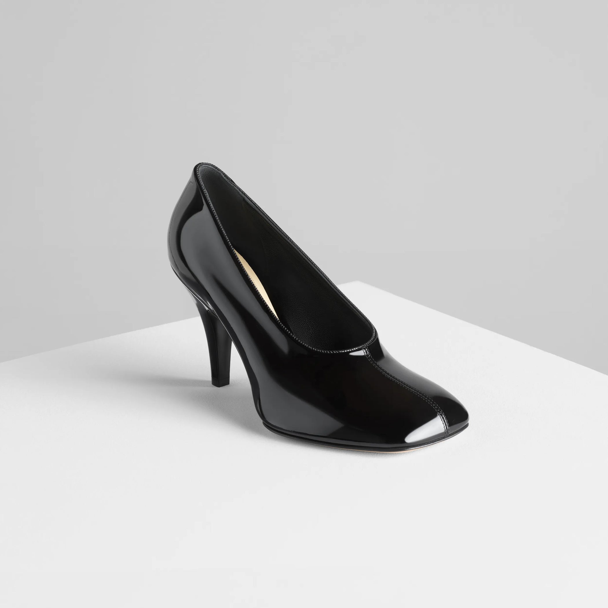 Angled view of soft pump 90 in black patent leather.