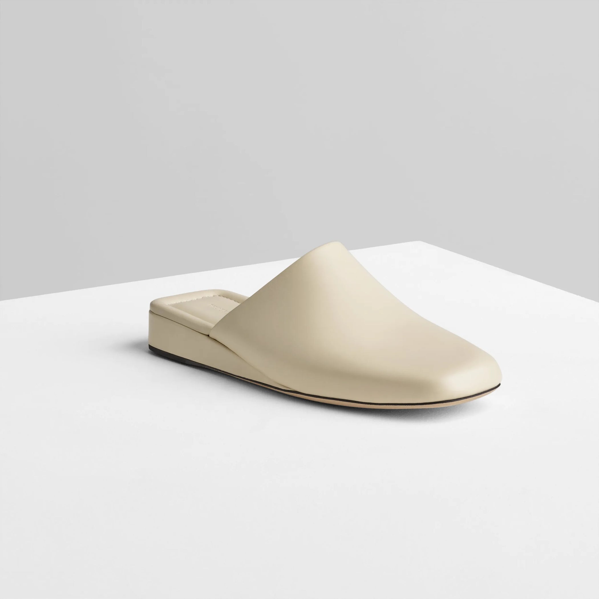 Angled view of robe slide in cream leather.