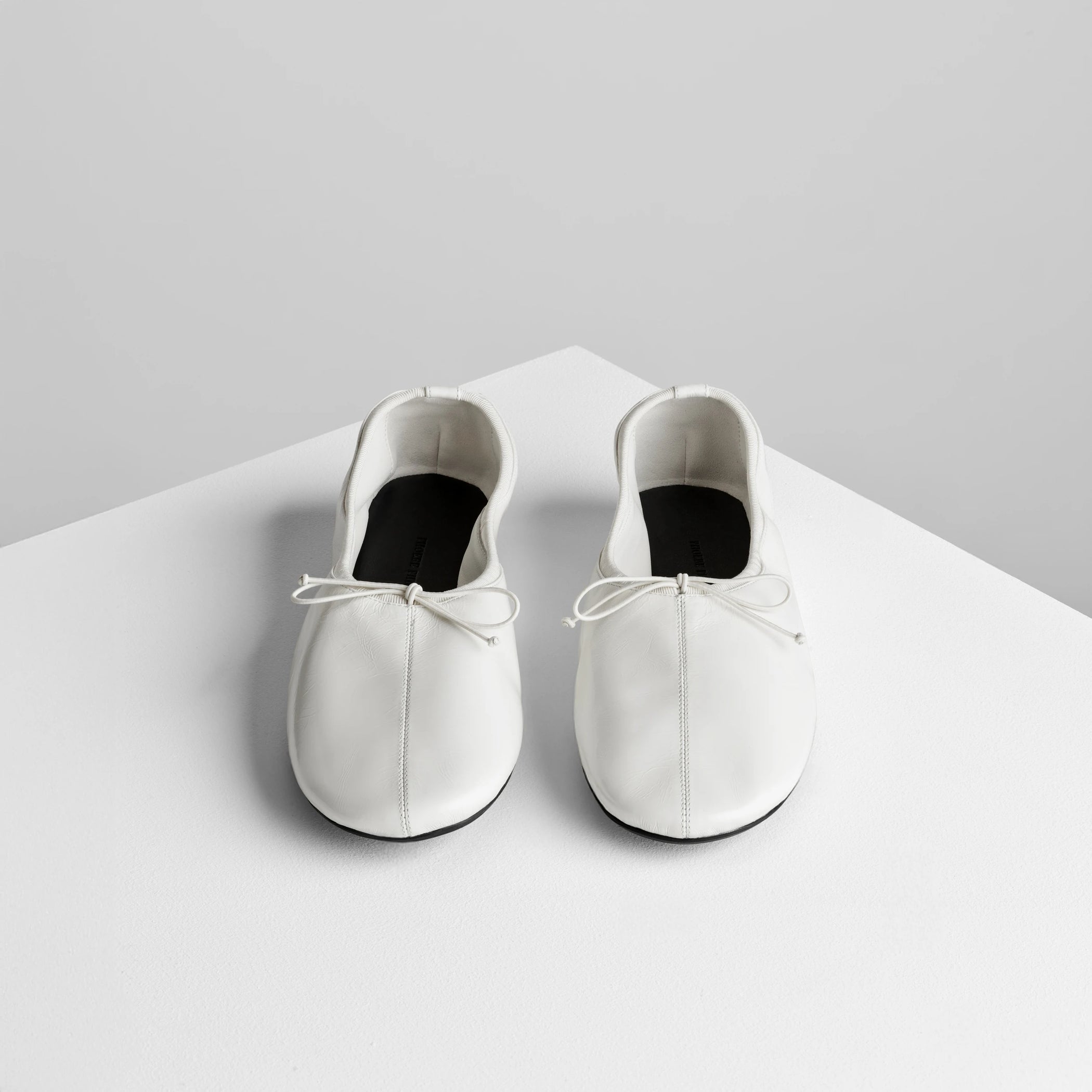 Front view of gathered flat in white leather.