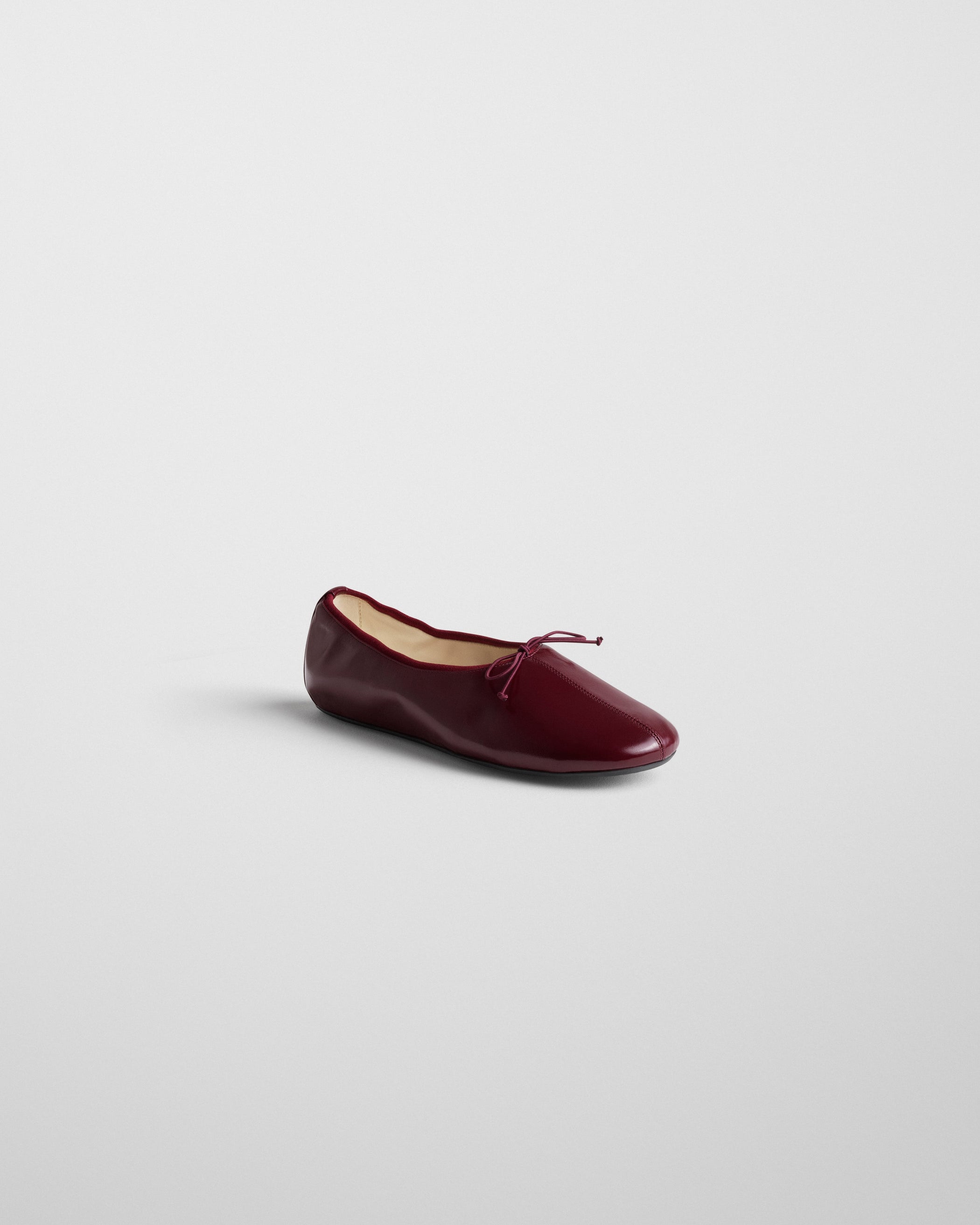 Angled side view of GATHERED FLAT in merlot leather