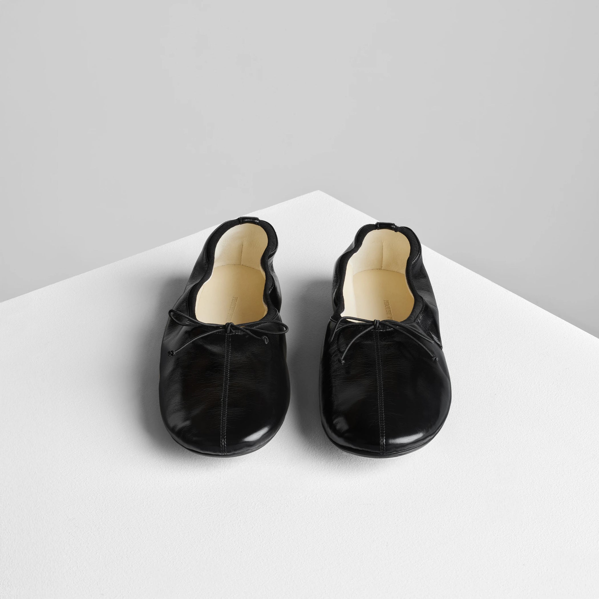 Front view of gathered flat in black leather.