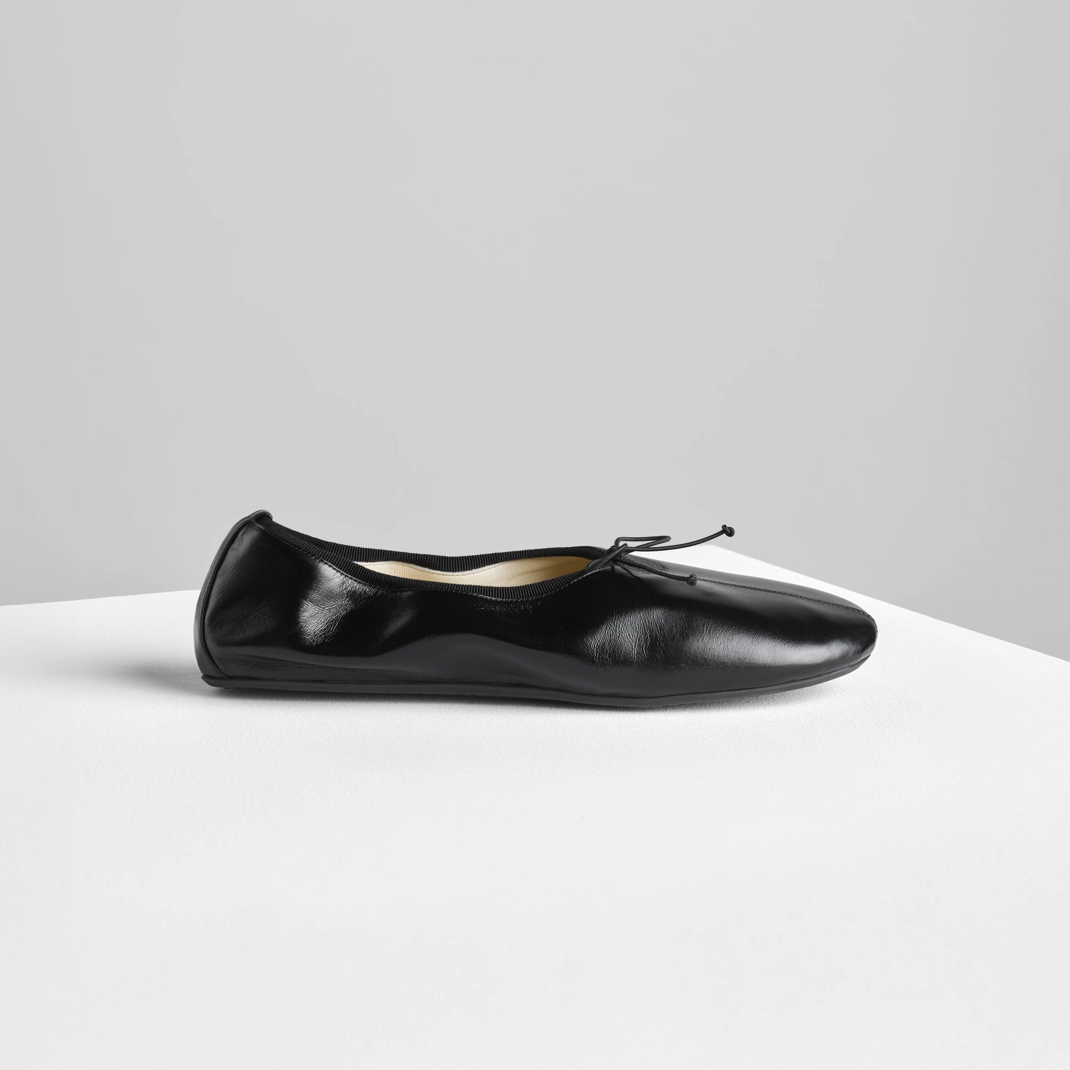Side view of gathered flat in black leather.