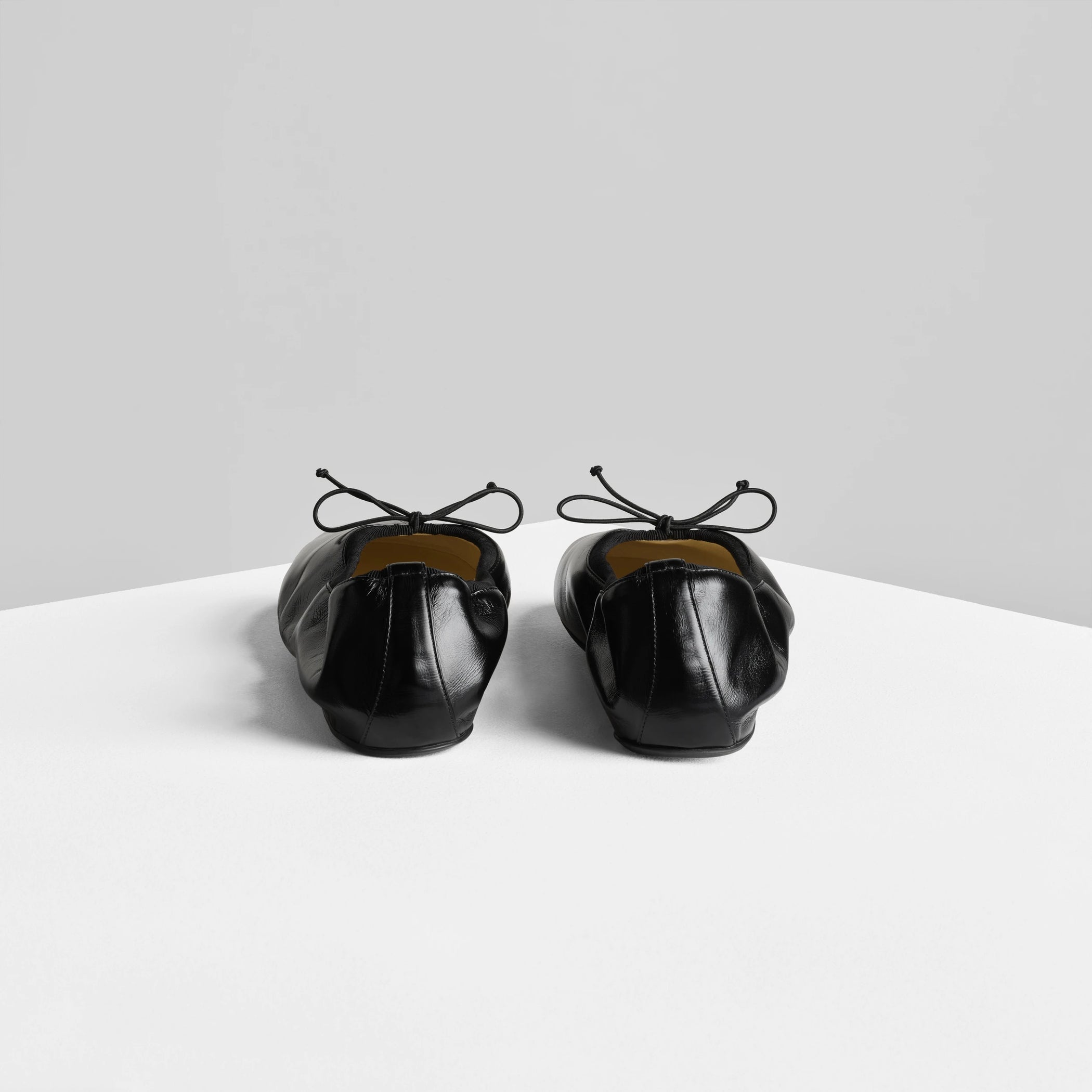 Back view of gathered flat in black leather.